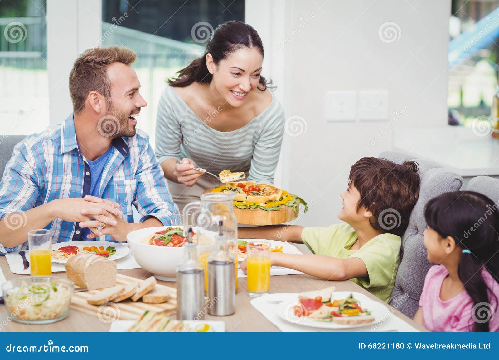 smiling mother serving food to children