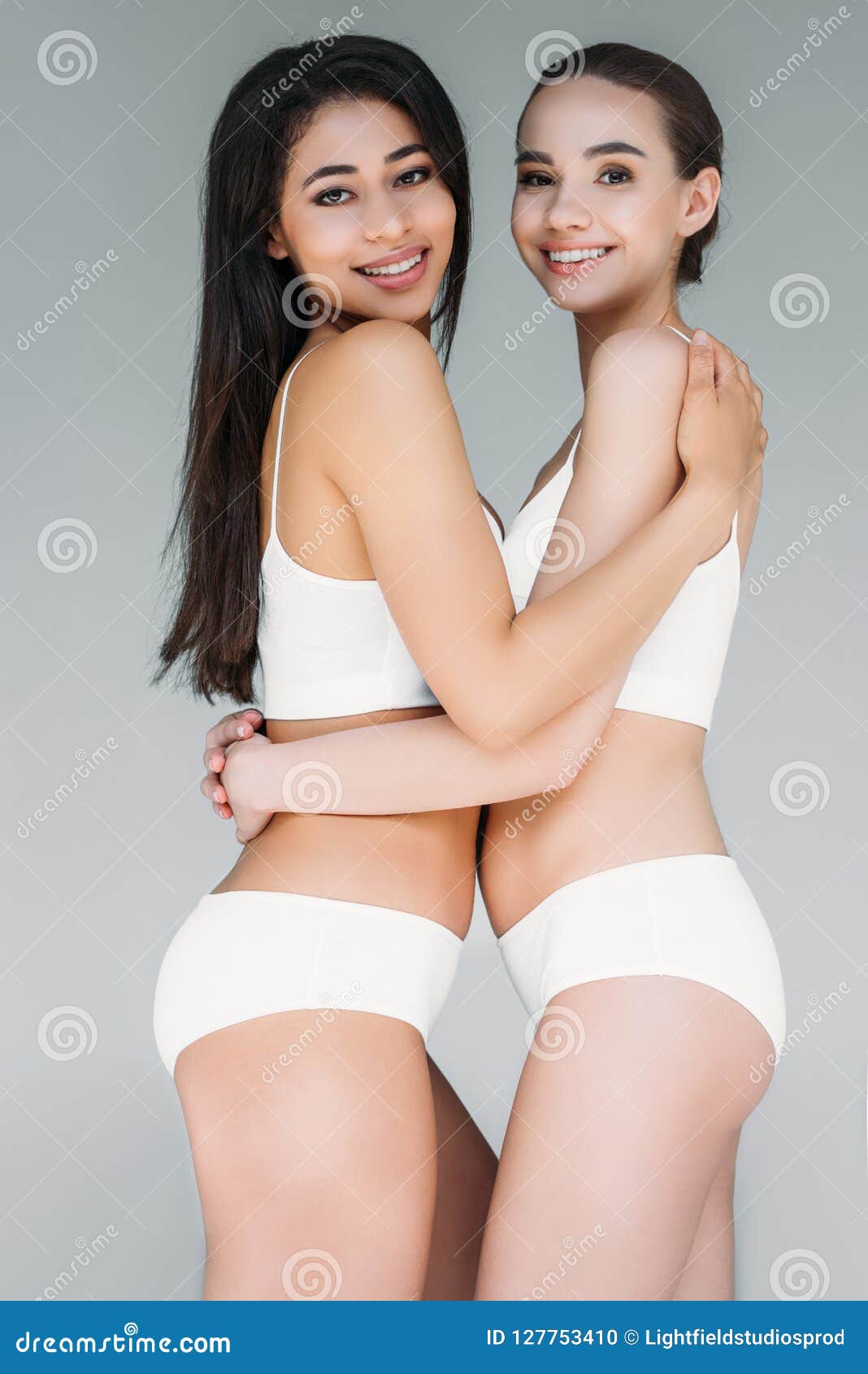 smiling multicultural women embracing each other