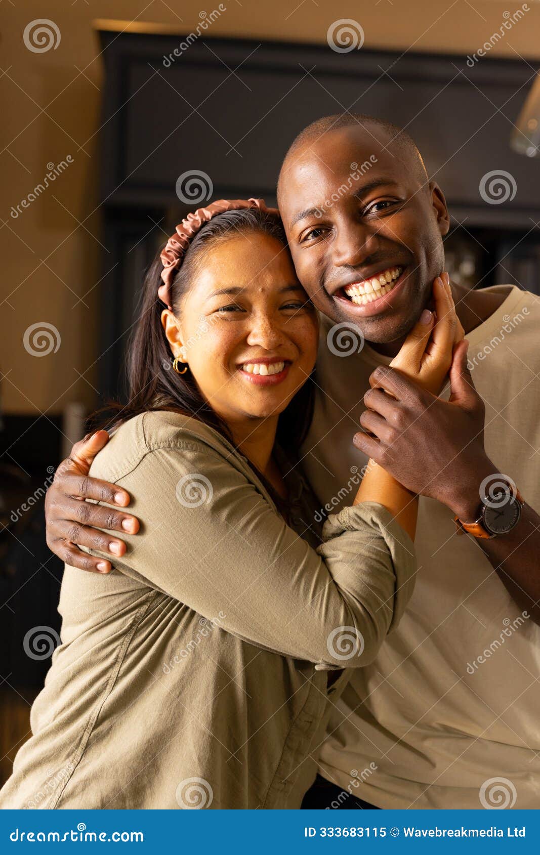 smiling multiracial couple embracing each other, enjoying quality time at home