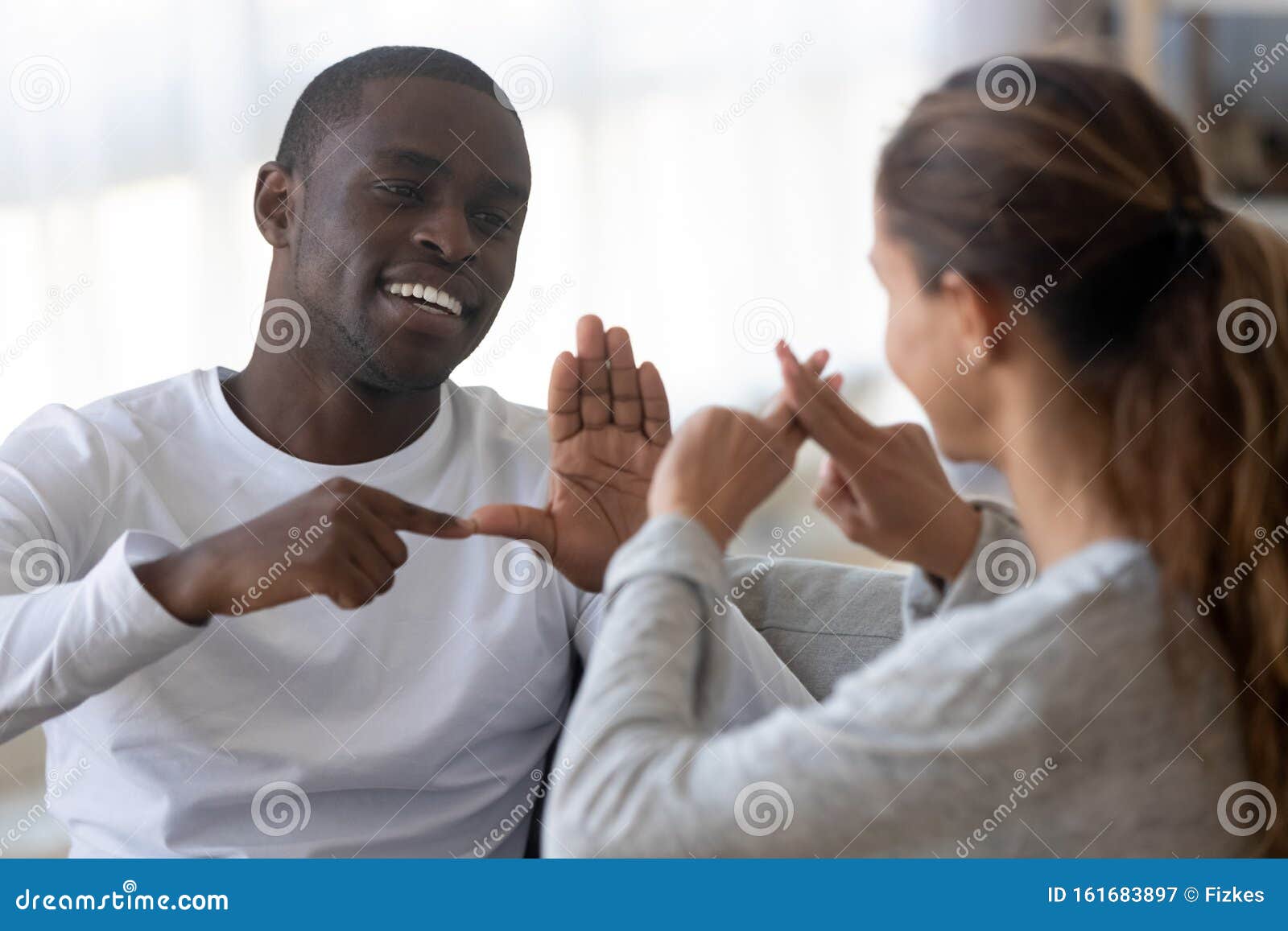 smiling multiracial friends talk using sign language