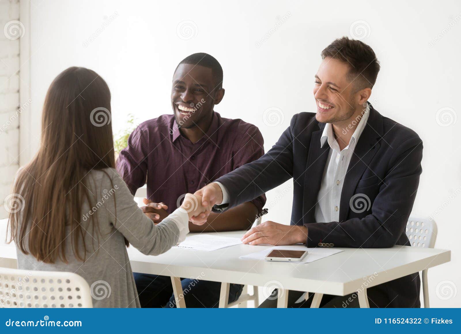 smiling hr handshaking female applicant at job interview, hiring