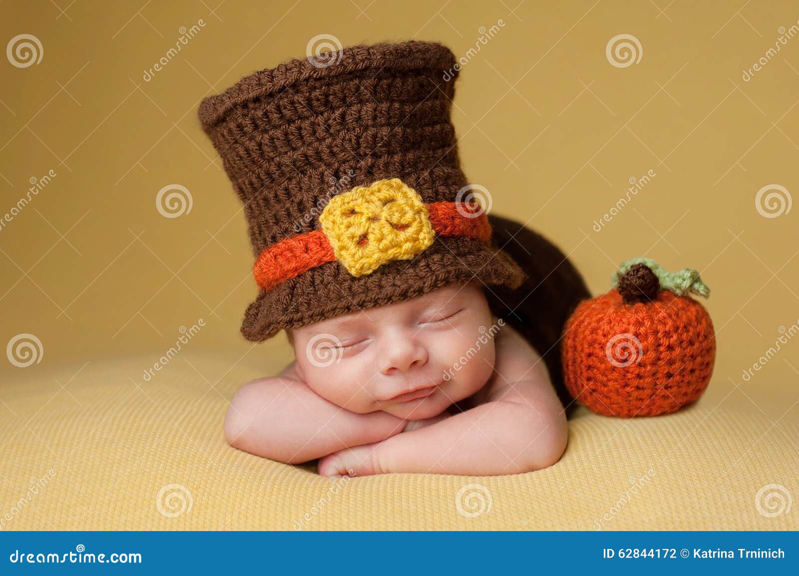 smiling newborn baby boy wearing a pilgrim hat