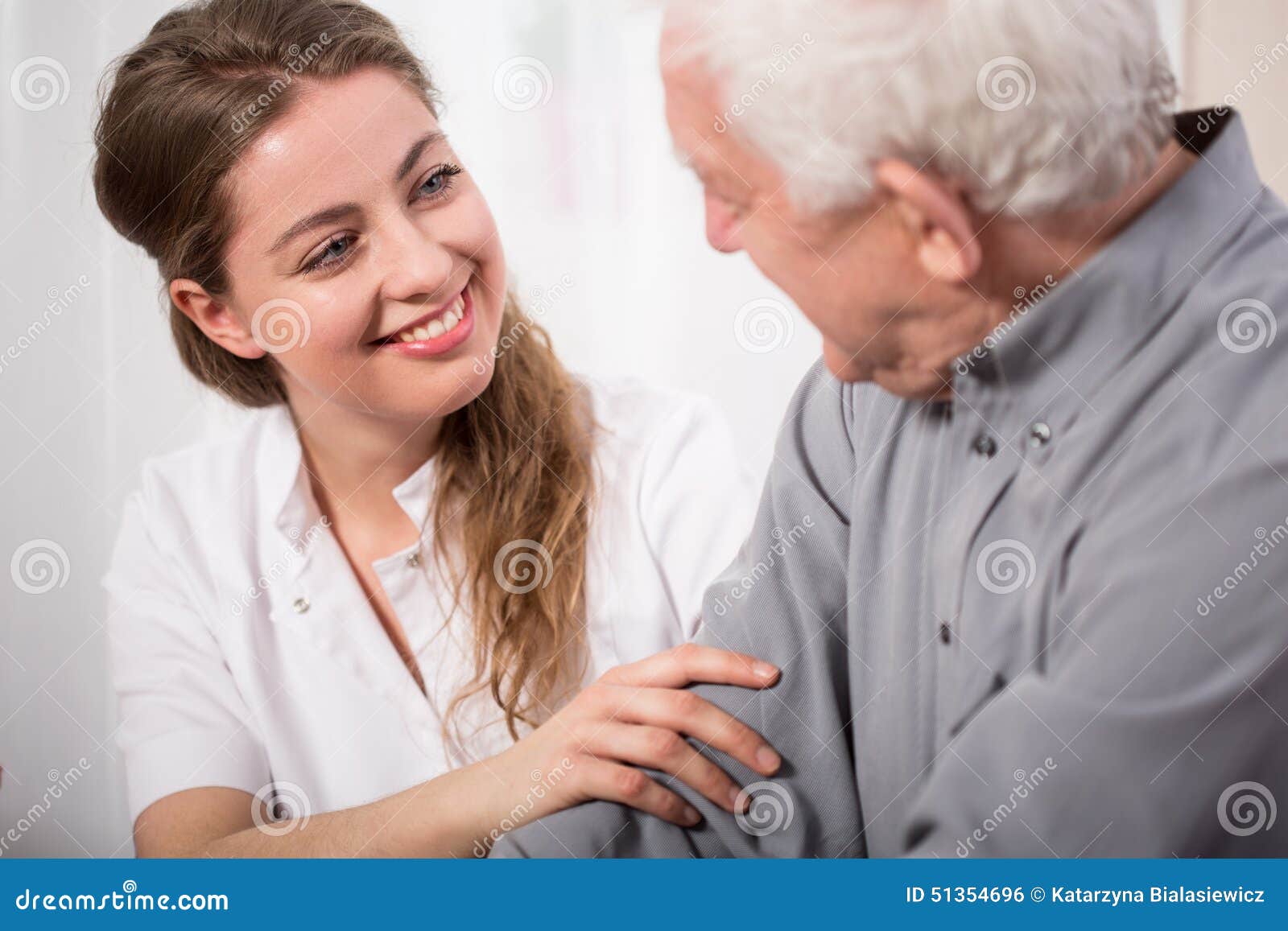 smiling nurse assisting senior man