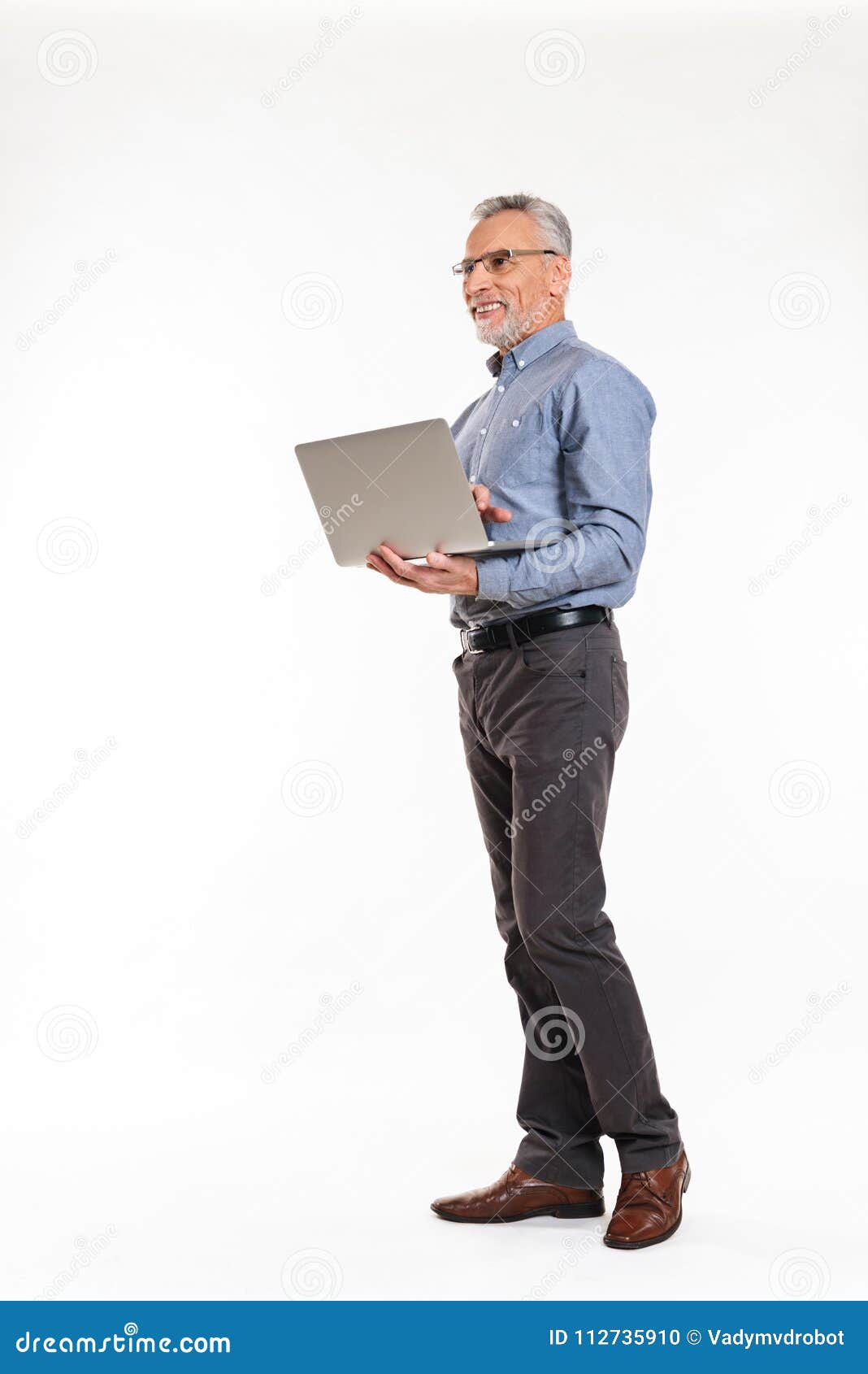 smiling old man using laptop computer and looking away 