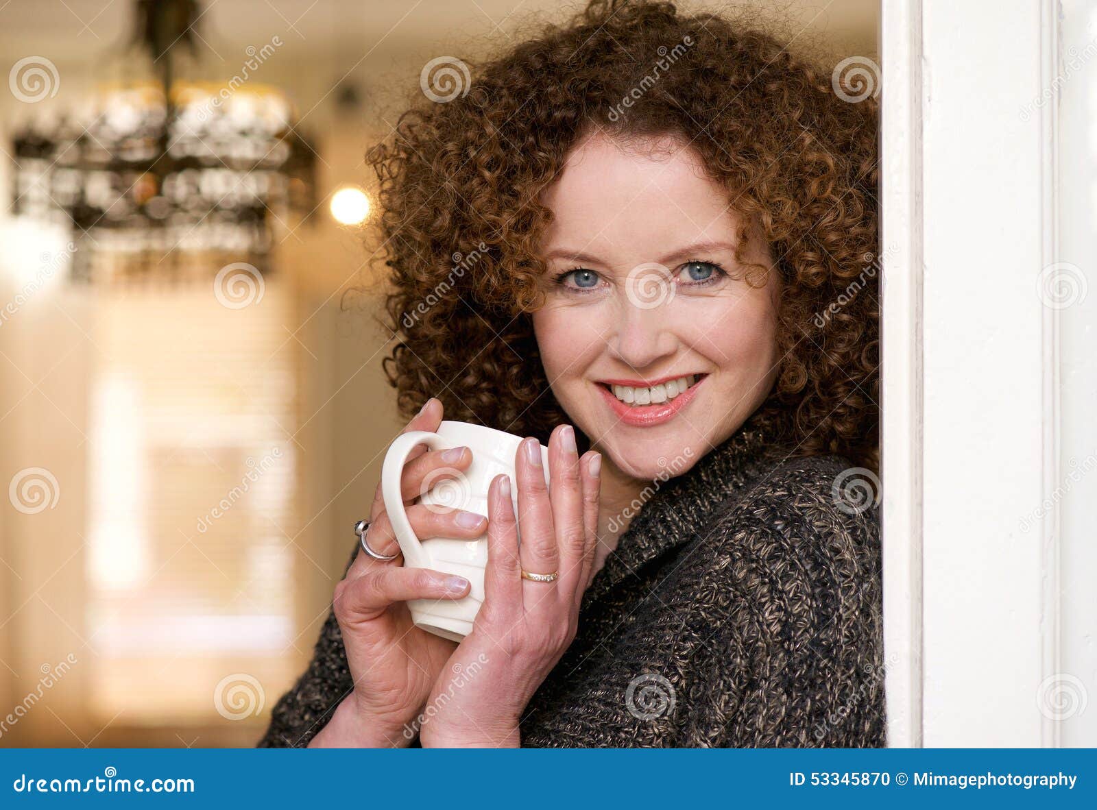 smiling older woman holding cup of tea