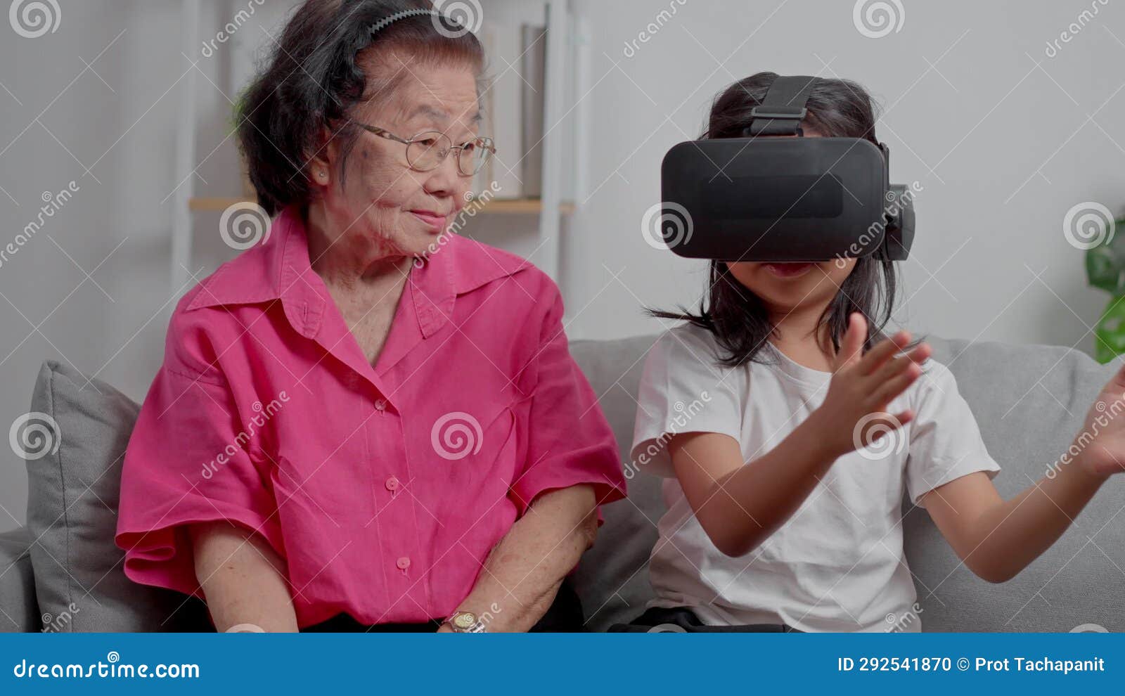 Smiling Overjoyed Mature Grandmother With Little Granddaughter Using Vr On Cozy Couch Happy