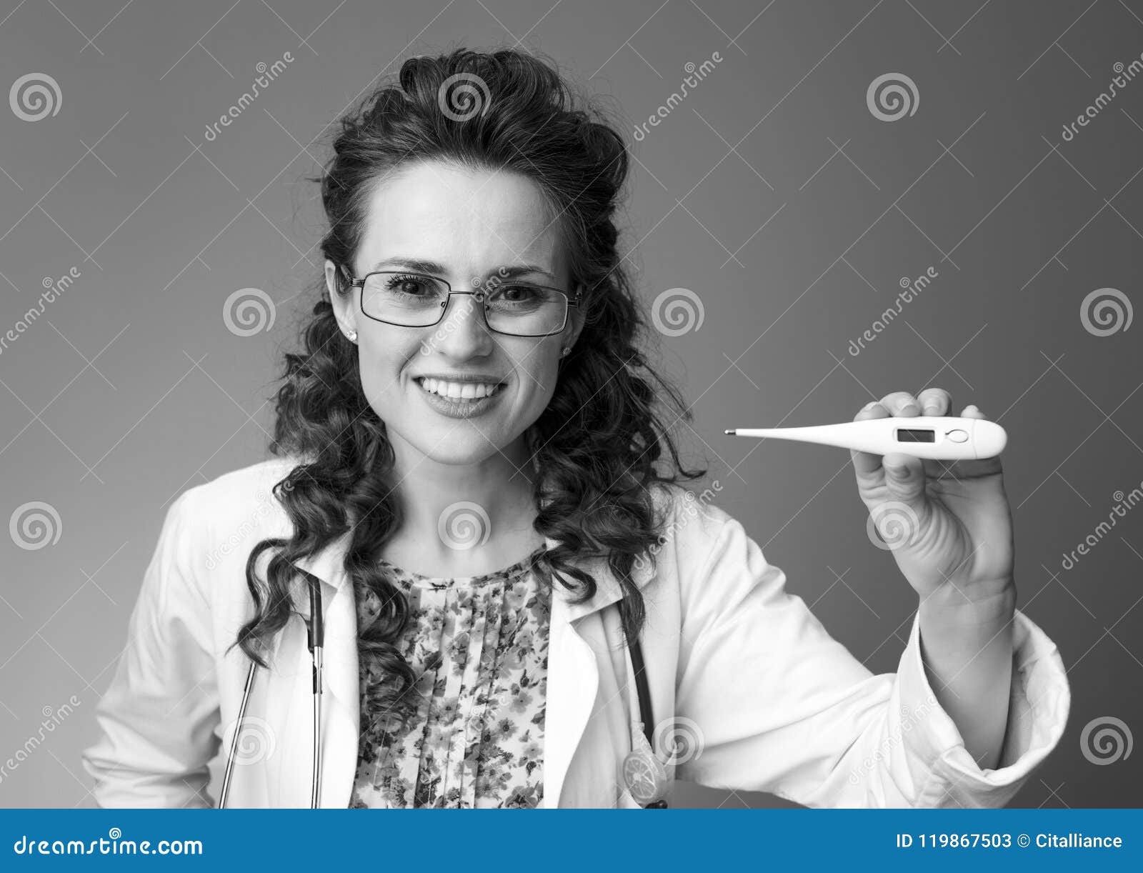 smiling paediatrician doctor showing thermometer on