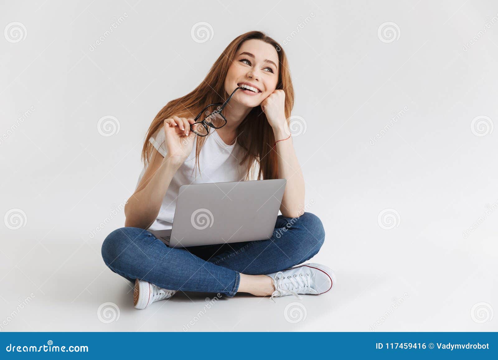 Smiling Pensive Woman in T-shirt Sitting on the Floor Stock Photo