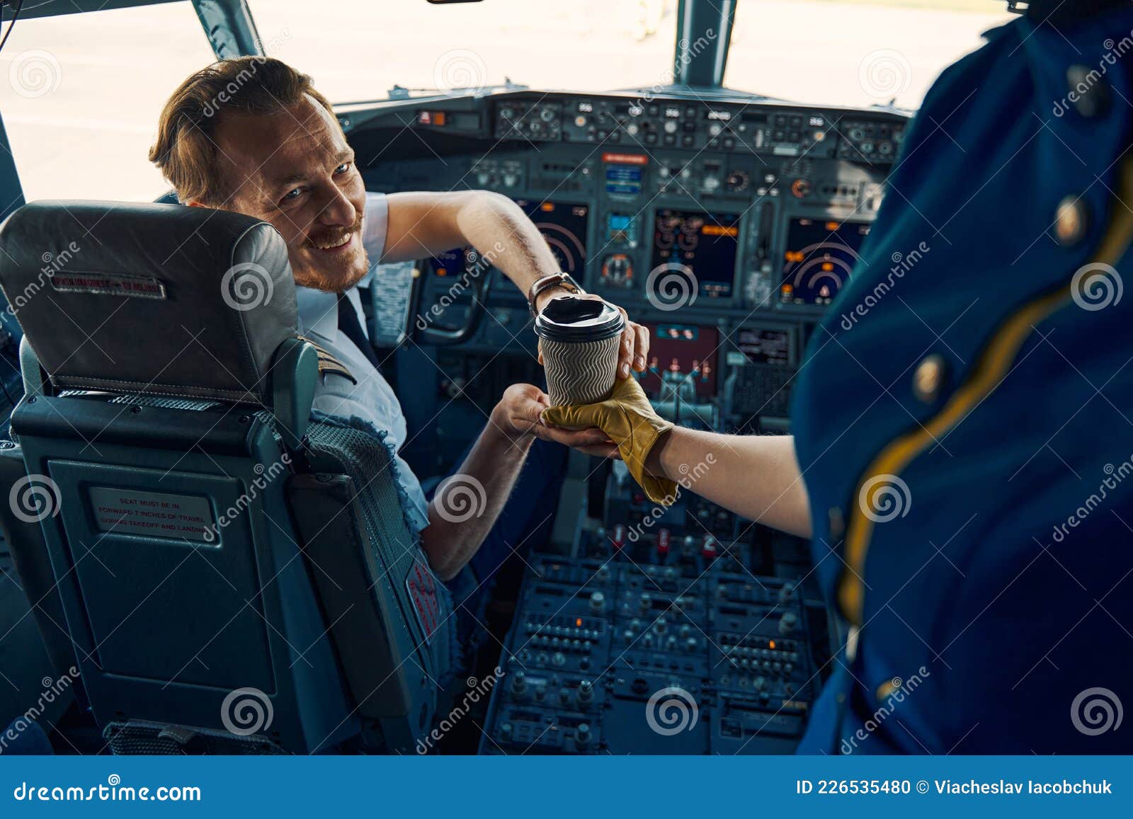 Airline Captain Being Served Coffee in the Cockpit Stock Airline Captain Being Served Coffee in the Cockpit Stock