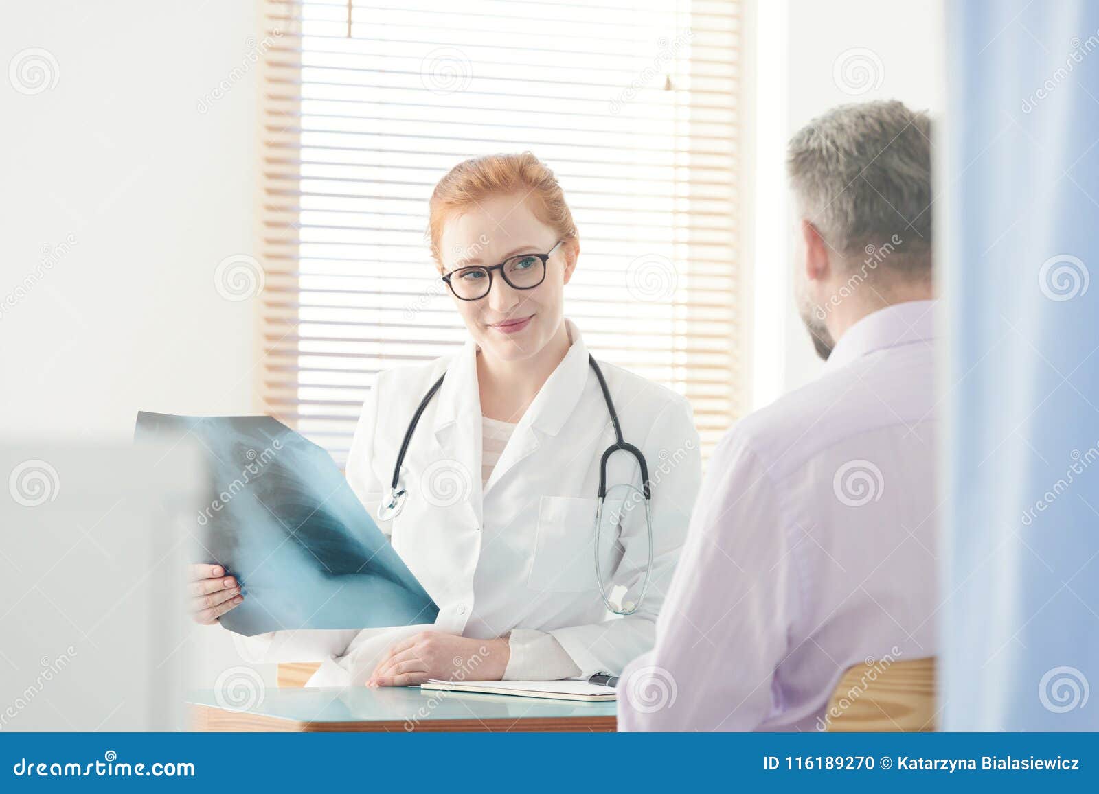 smiling pulmonologist watching x-ray image