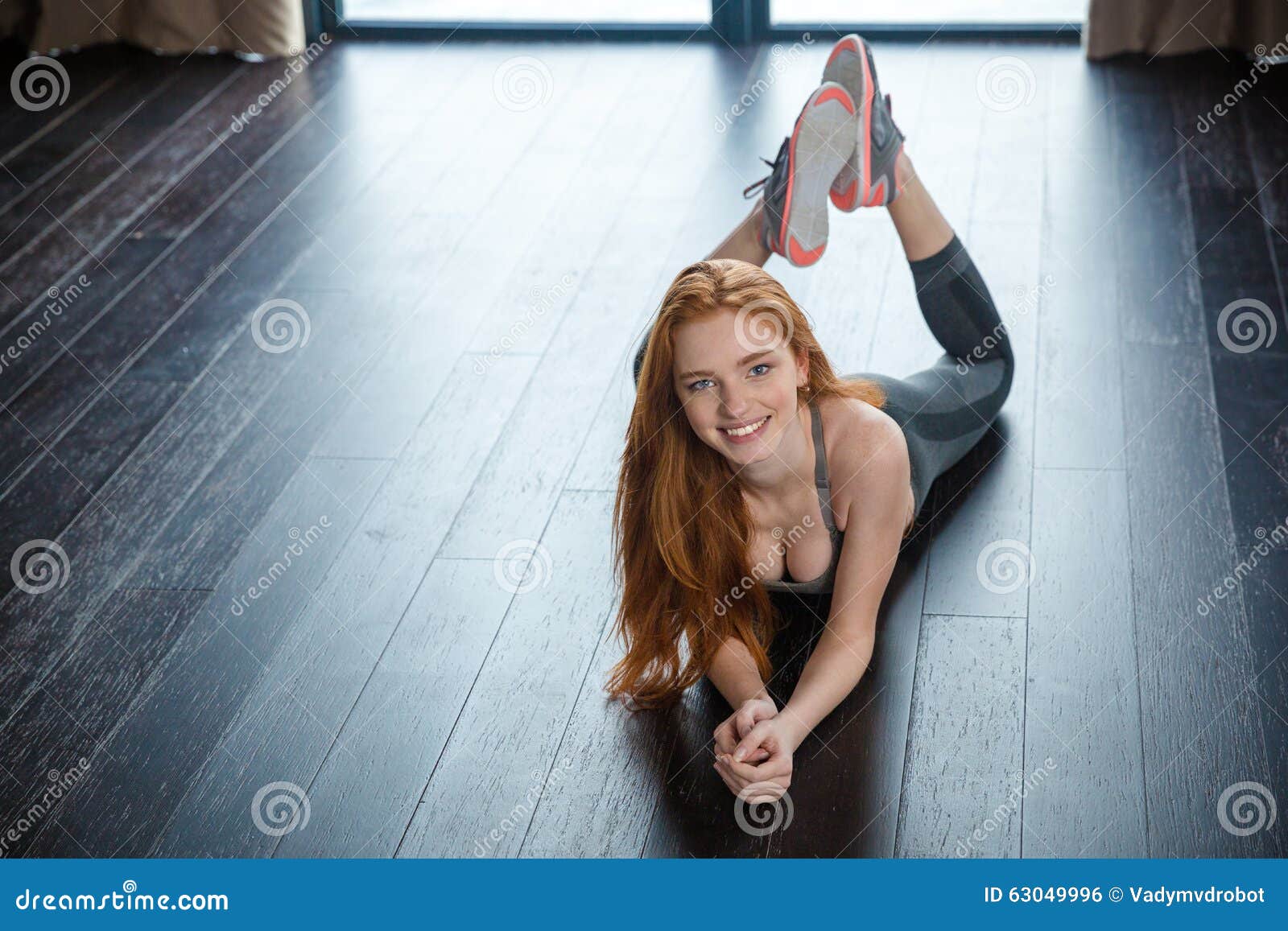smiling redhead woman lying on the floor