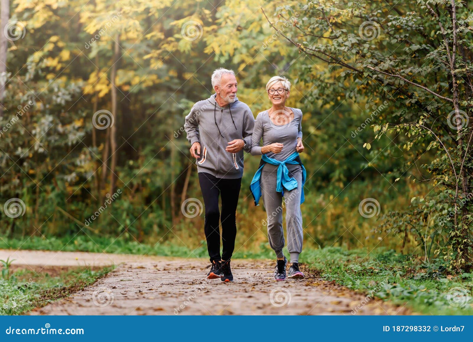 smiling senior couple jogging in the park