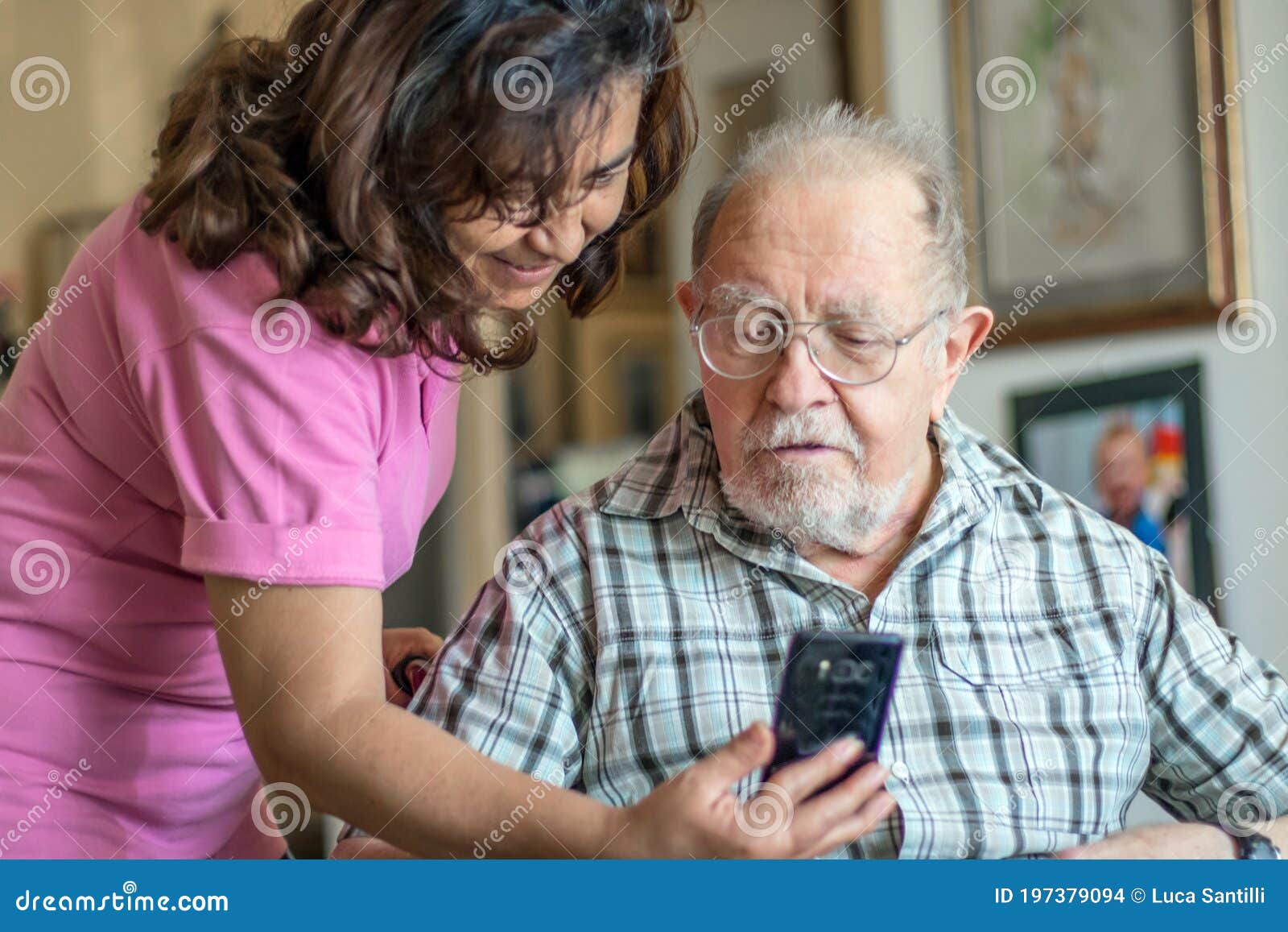 a smiling senior man and caregiver with smartphone are doing a videocall