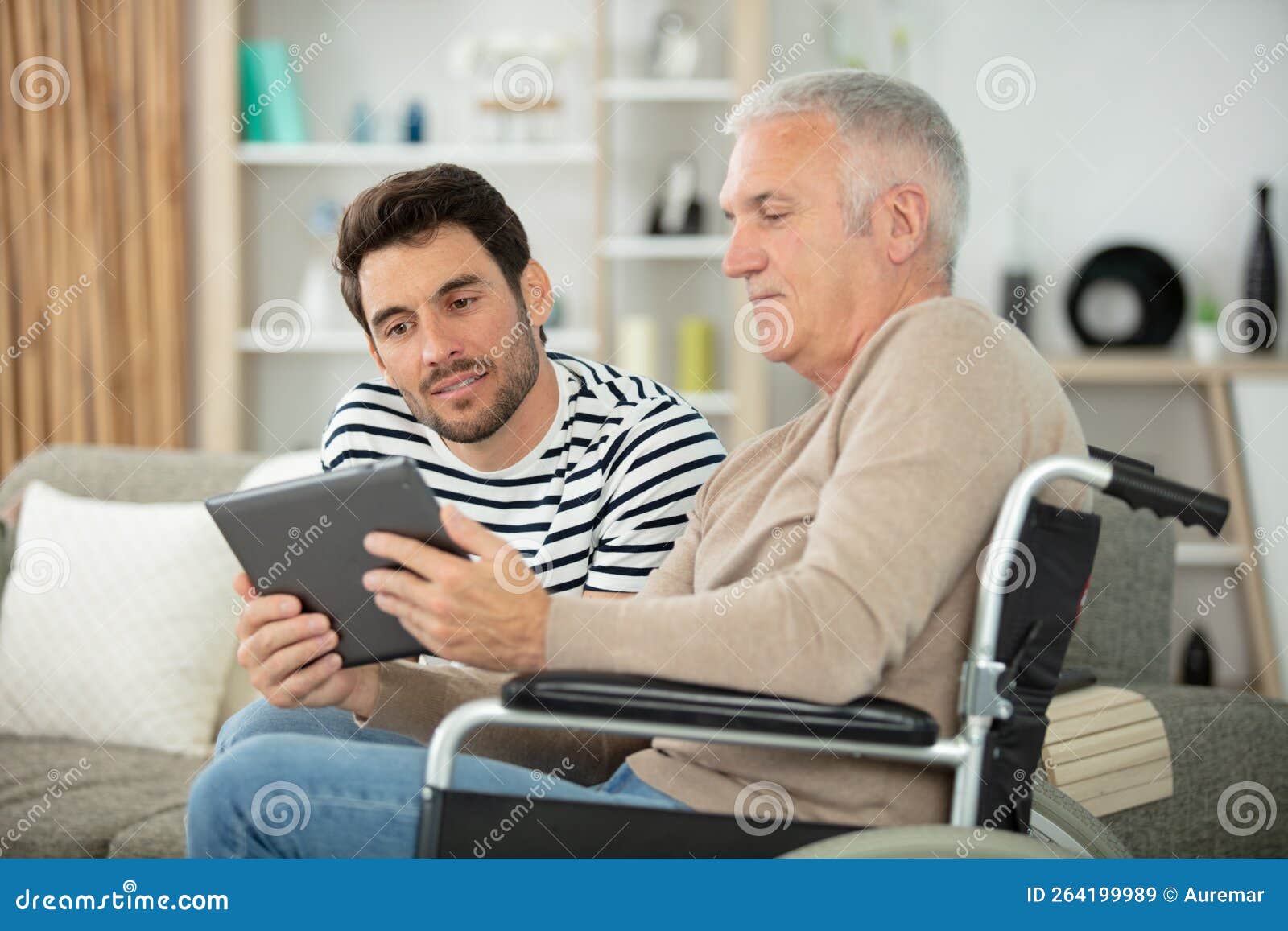 smiling son and father in wheelchair with tablet