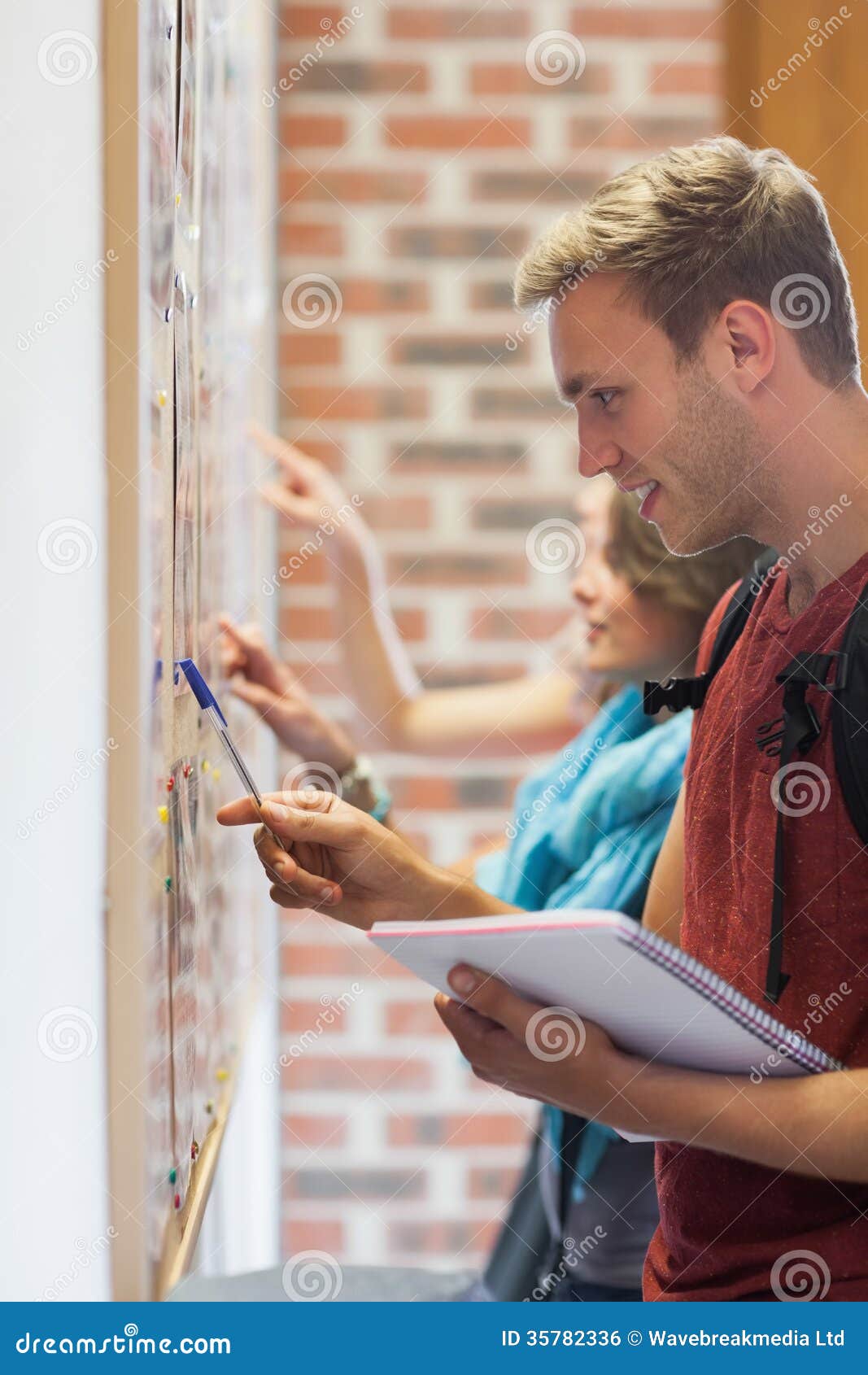 Smiling Students Searching Something On Notice Board Stock Photo ...