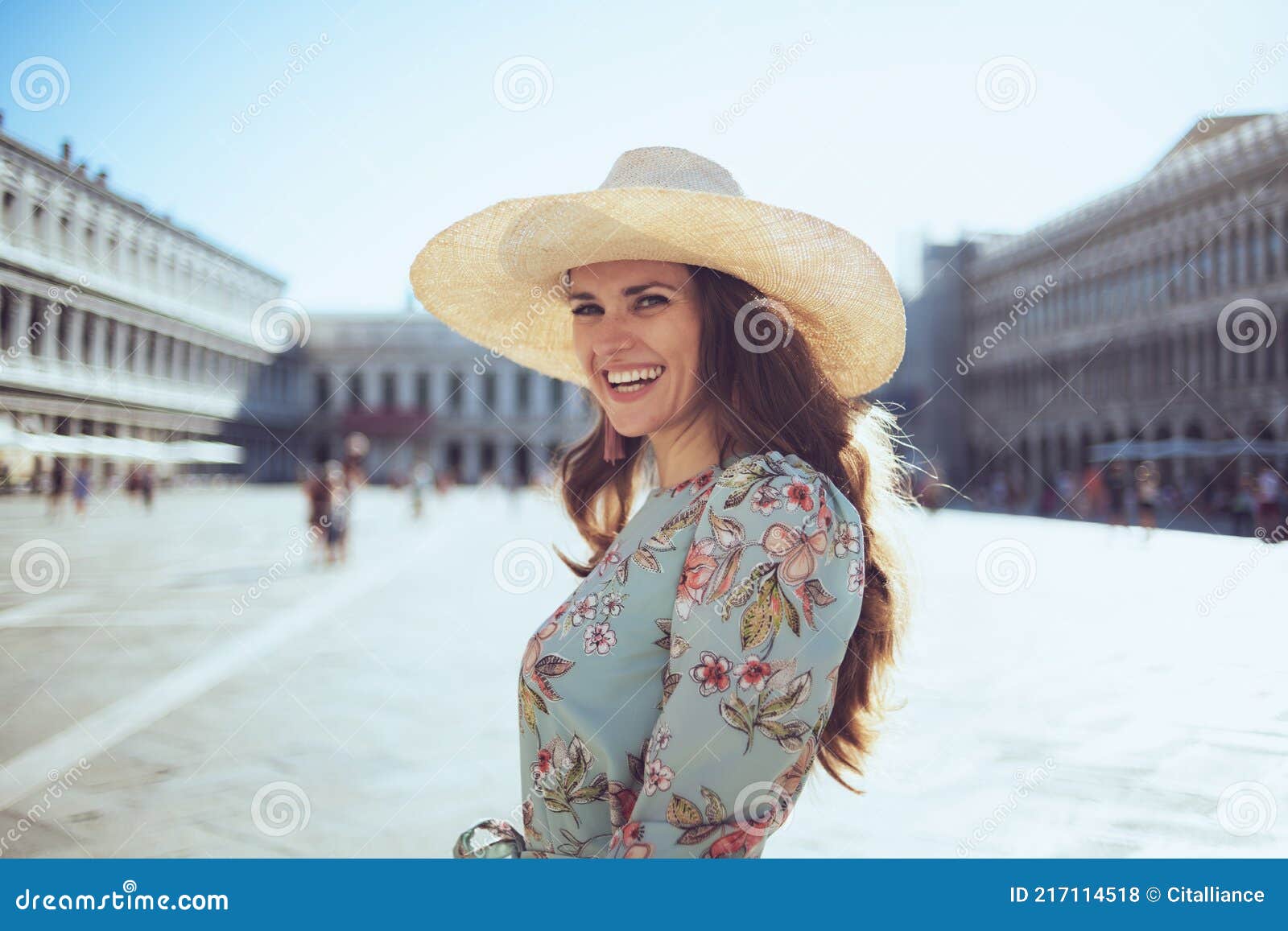 smiling stylish traveller woman in floral dress with hat