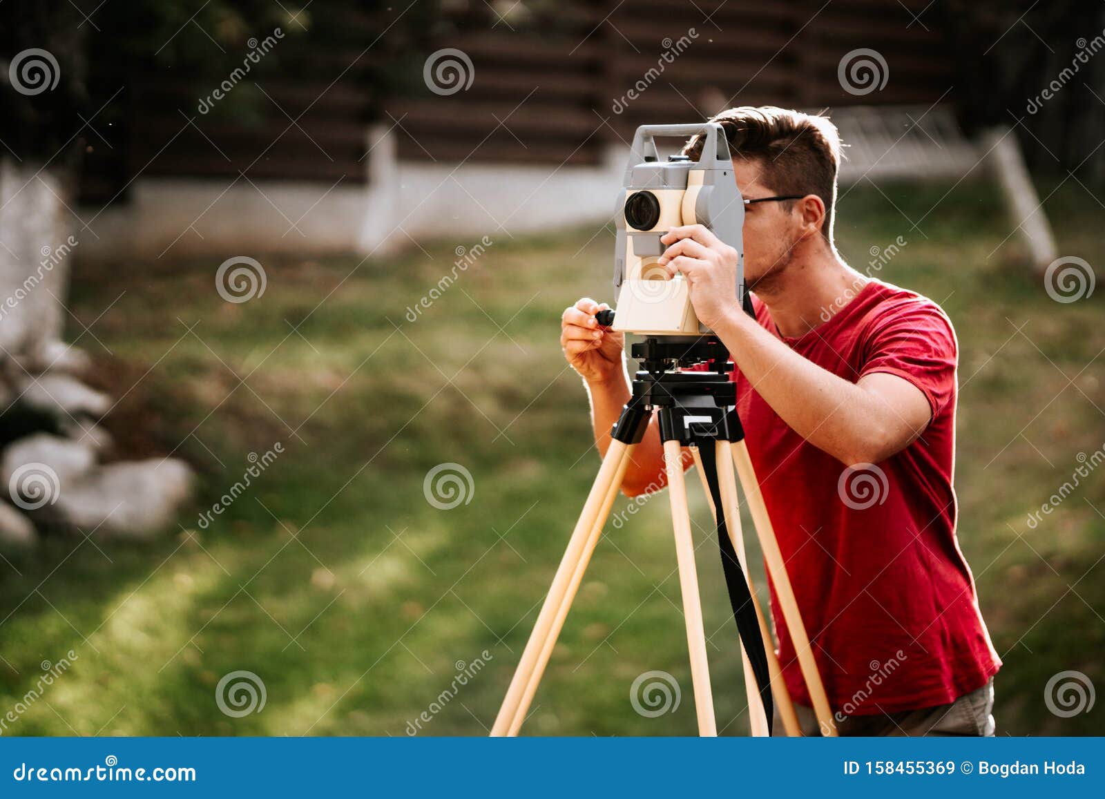 smiling surveyor working with total station with coordinates, cartography industry details