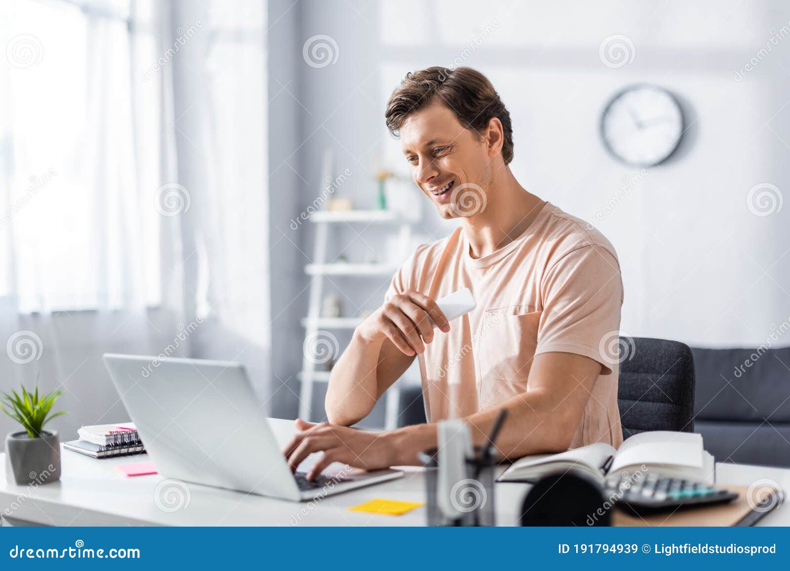 smiling teleworker looking at laptop and