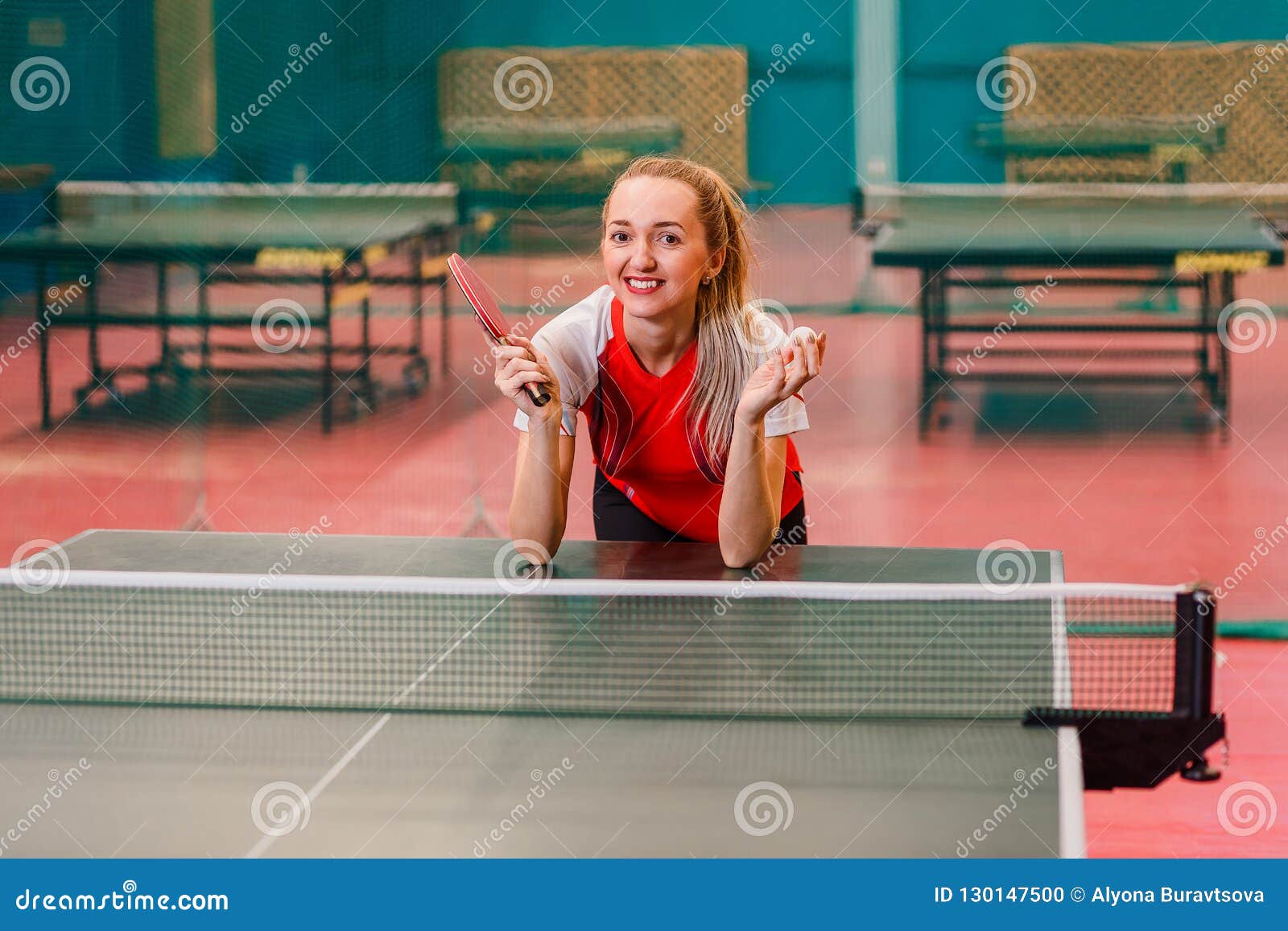 The Smiling Tennis Player Standing at the Table for Table Tennis Stock