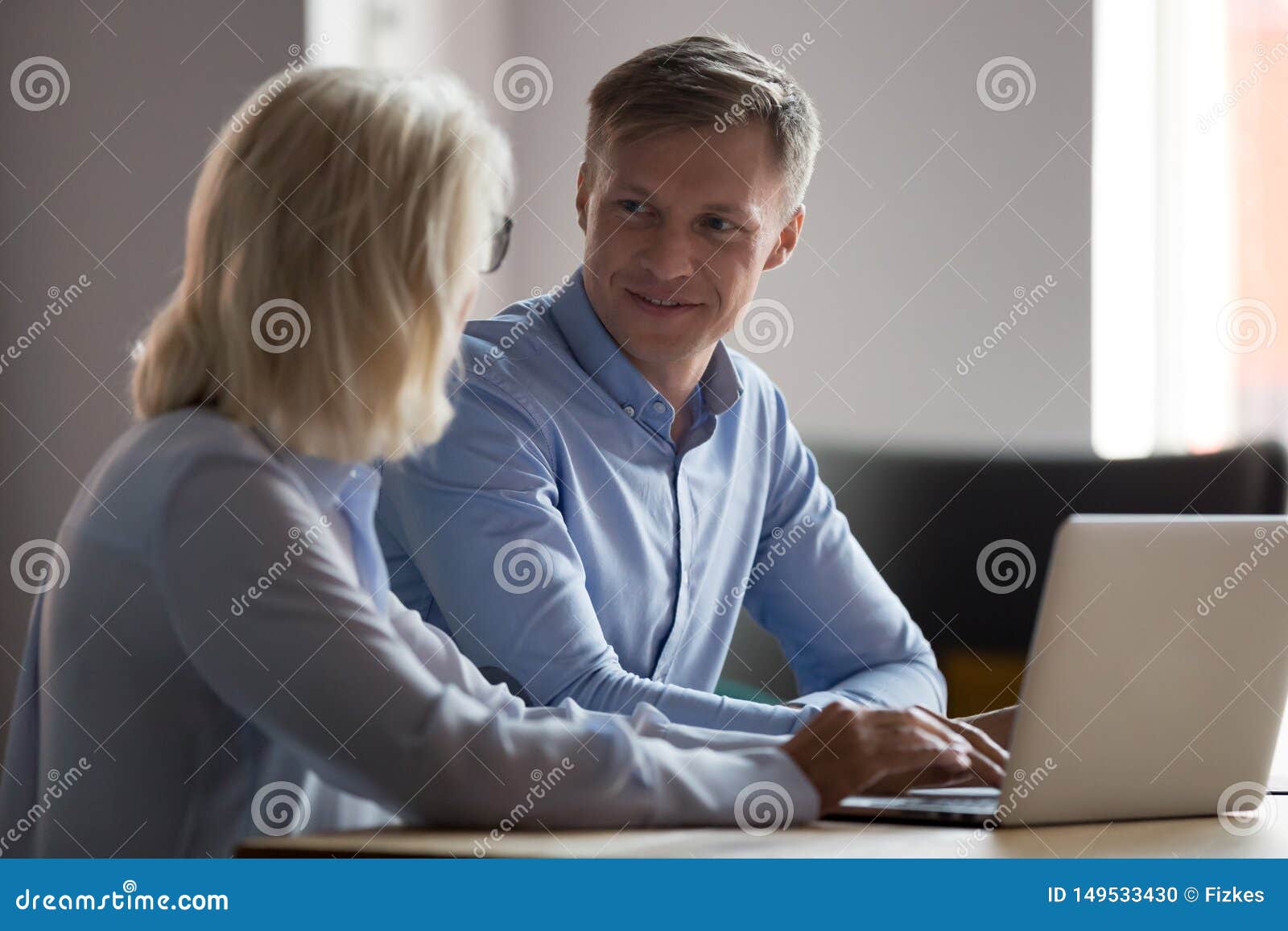 trainee talking with mature businesswoman, mentor, working together