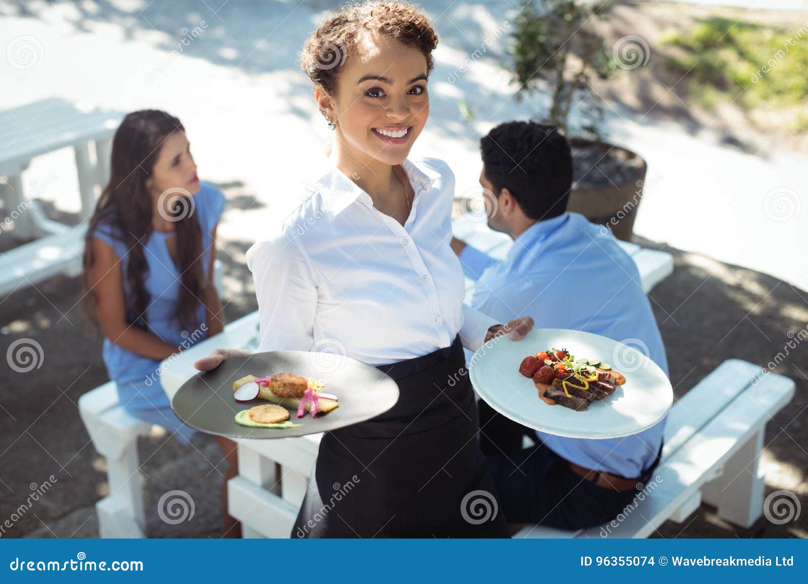 Smiling Waitress Holding Delicious Food In Kitchen Stock Photo Image