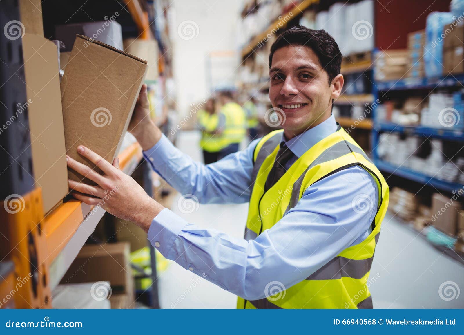 Smiling Warehouse Worker Taking Package in the Shelf Stock Photo
