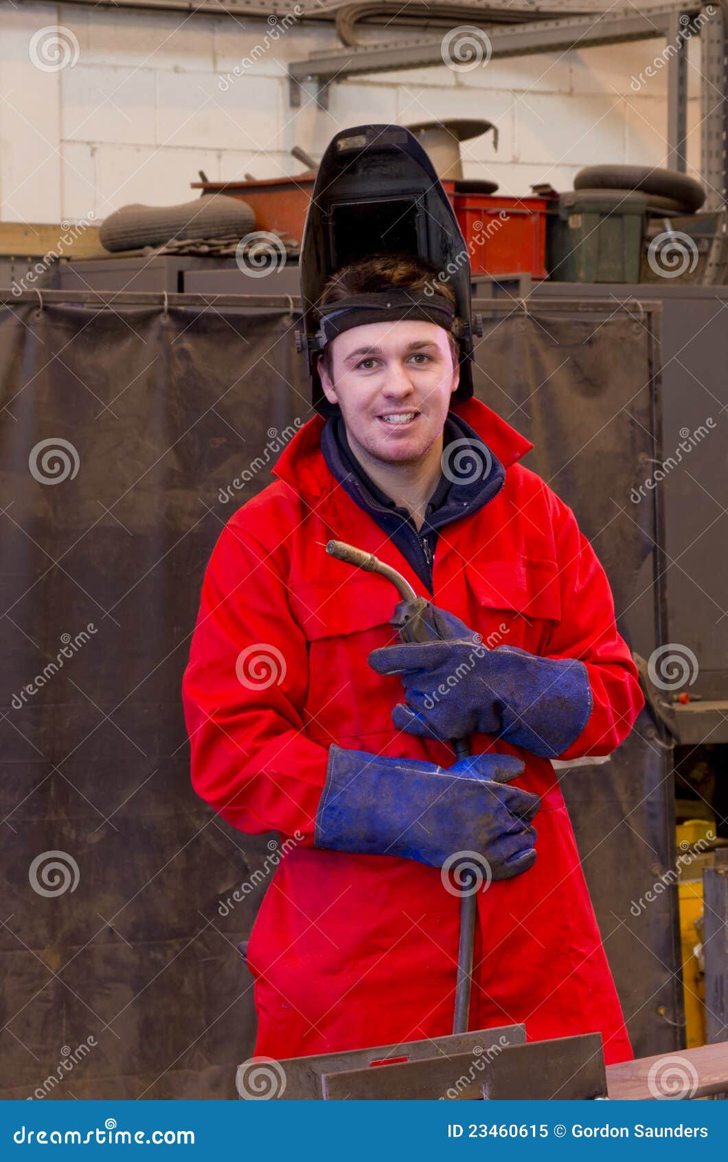 smiling welder with safety visor and torch