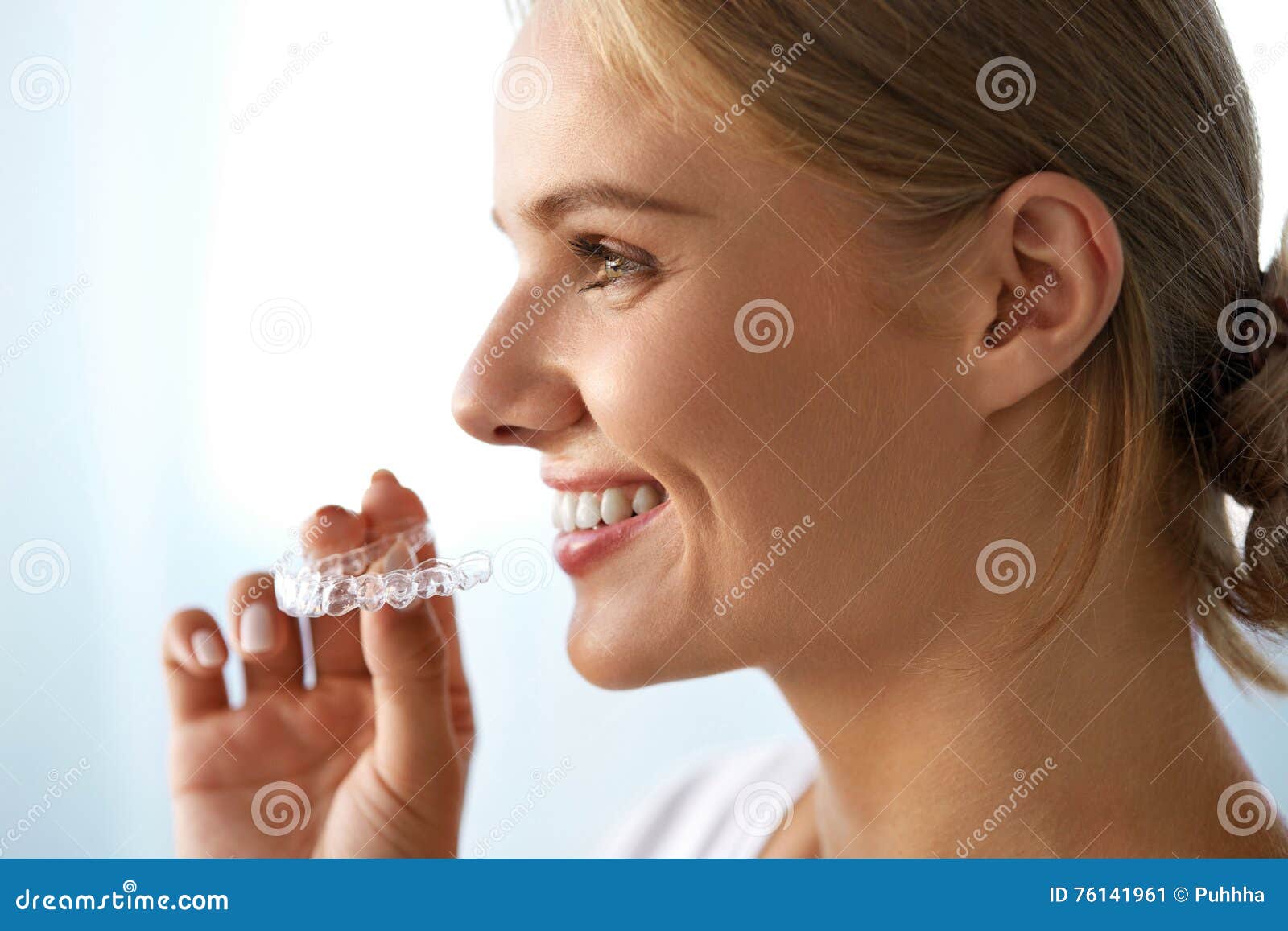 smiling woman with beautiful smile using invisible teeth trainer