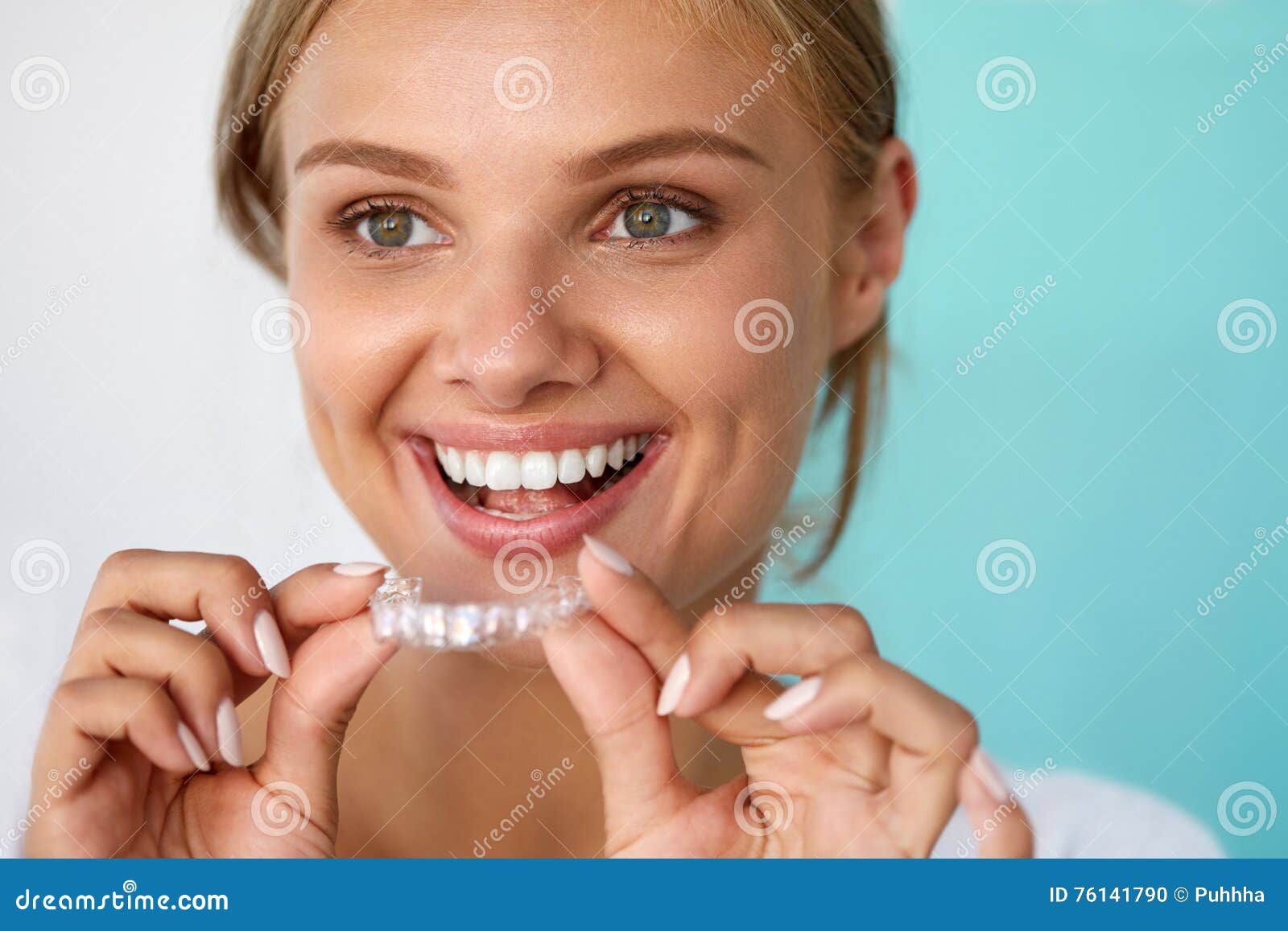 smiling woman with beautiful smile using teeth whitening tray