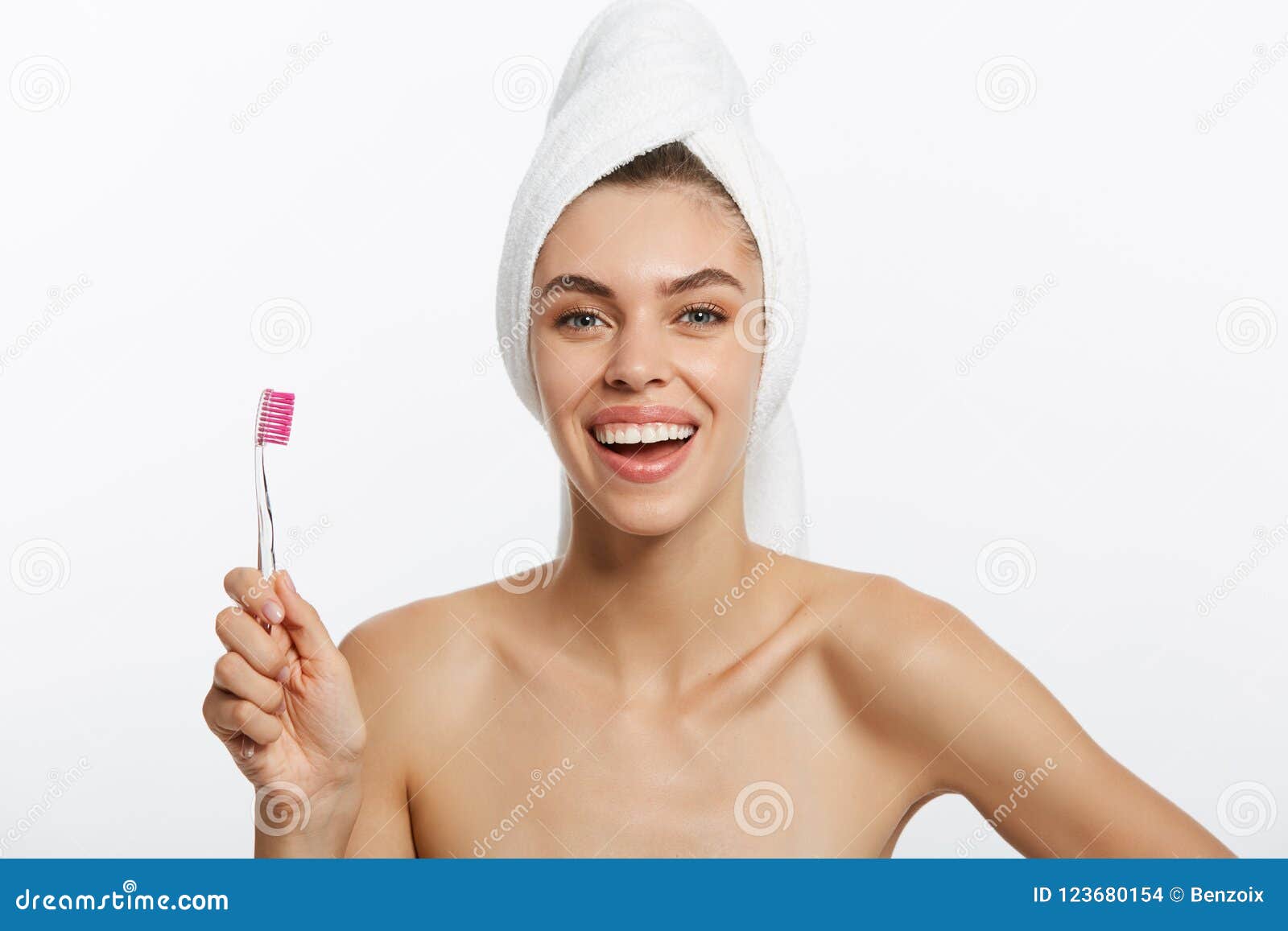 smiling woman brushing her teeth with towel on her head. a great smile
