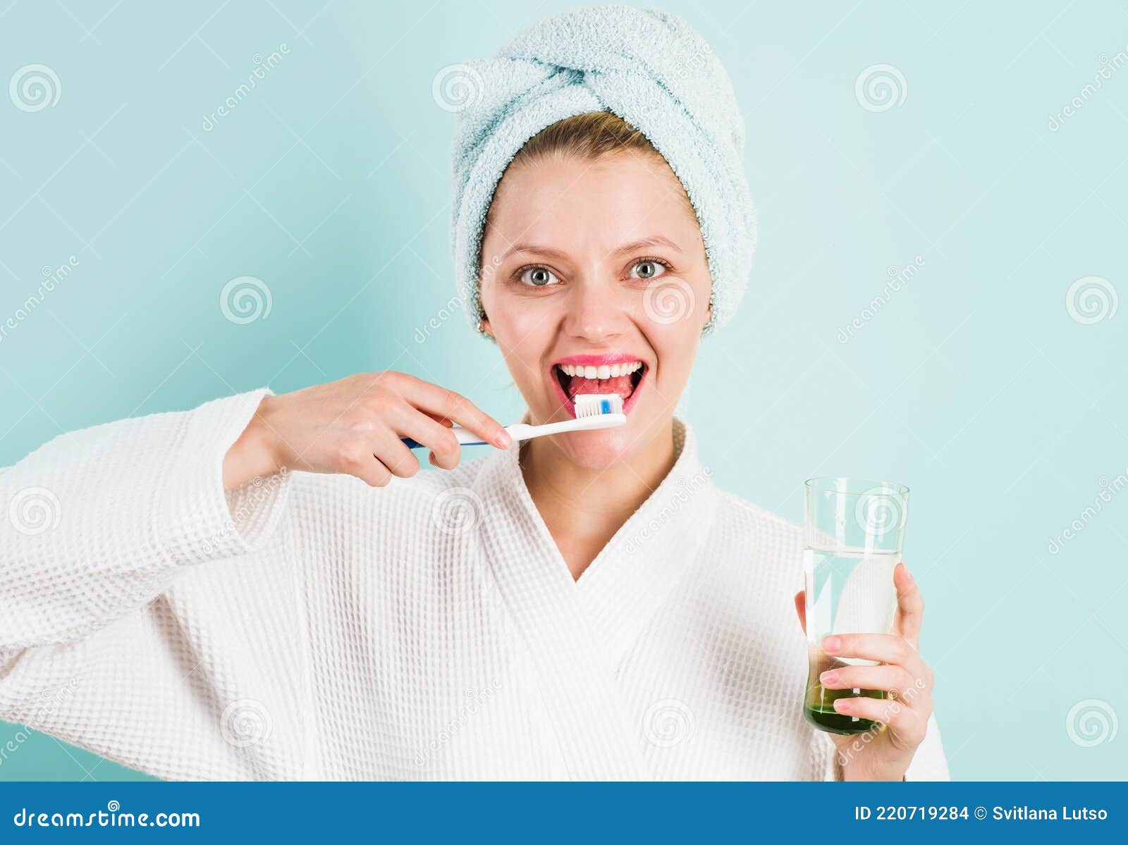 smiling woman brushing teeth with toothpaste and toothbrush in bathroom. dental higiene. ceaning teeth.