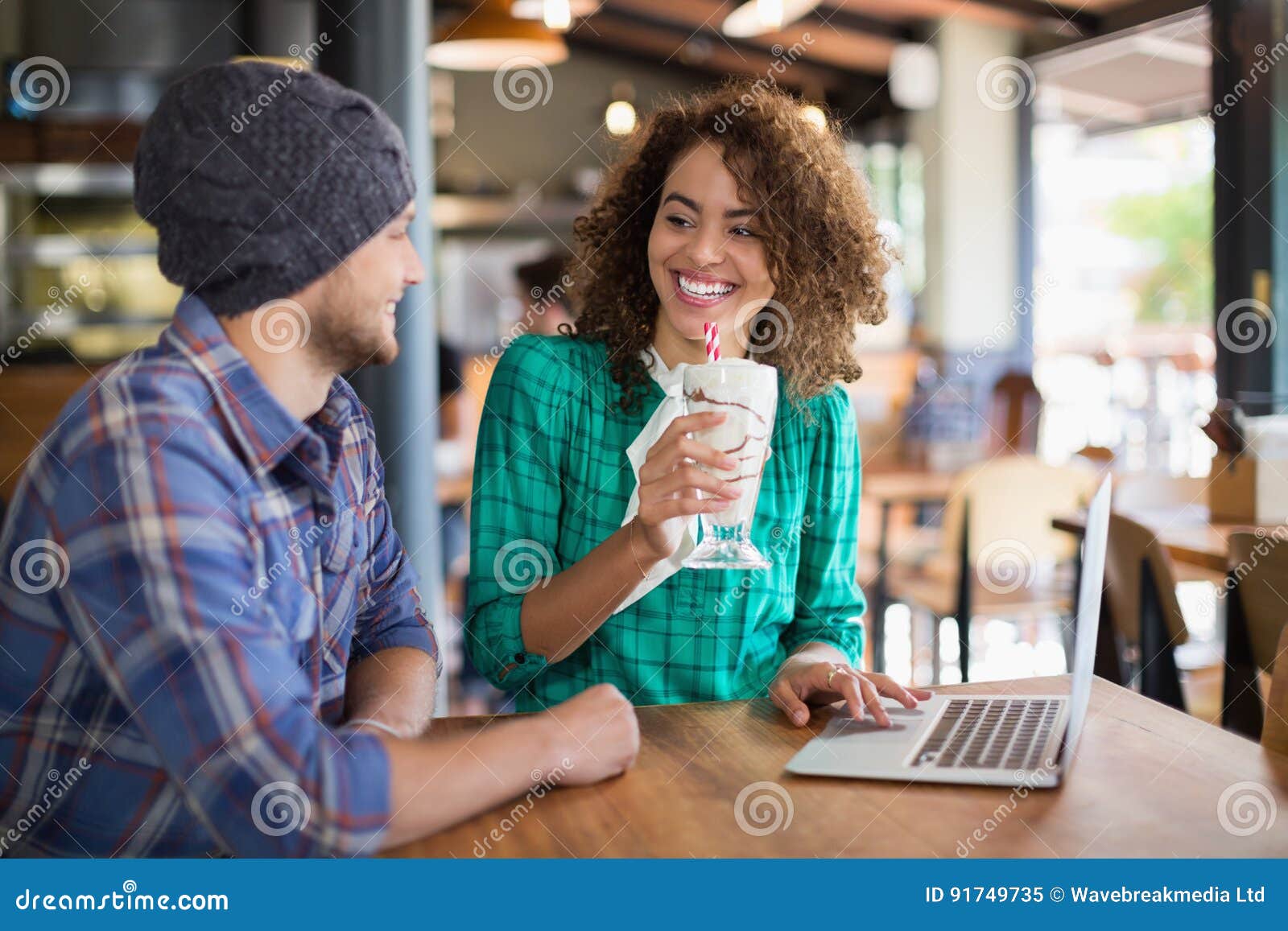 Smiling Woman Having Smoothie while Looking at Male Friend Sitting ...