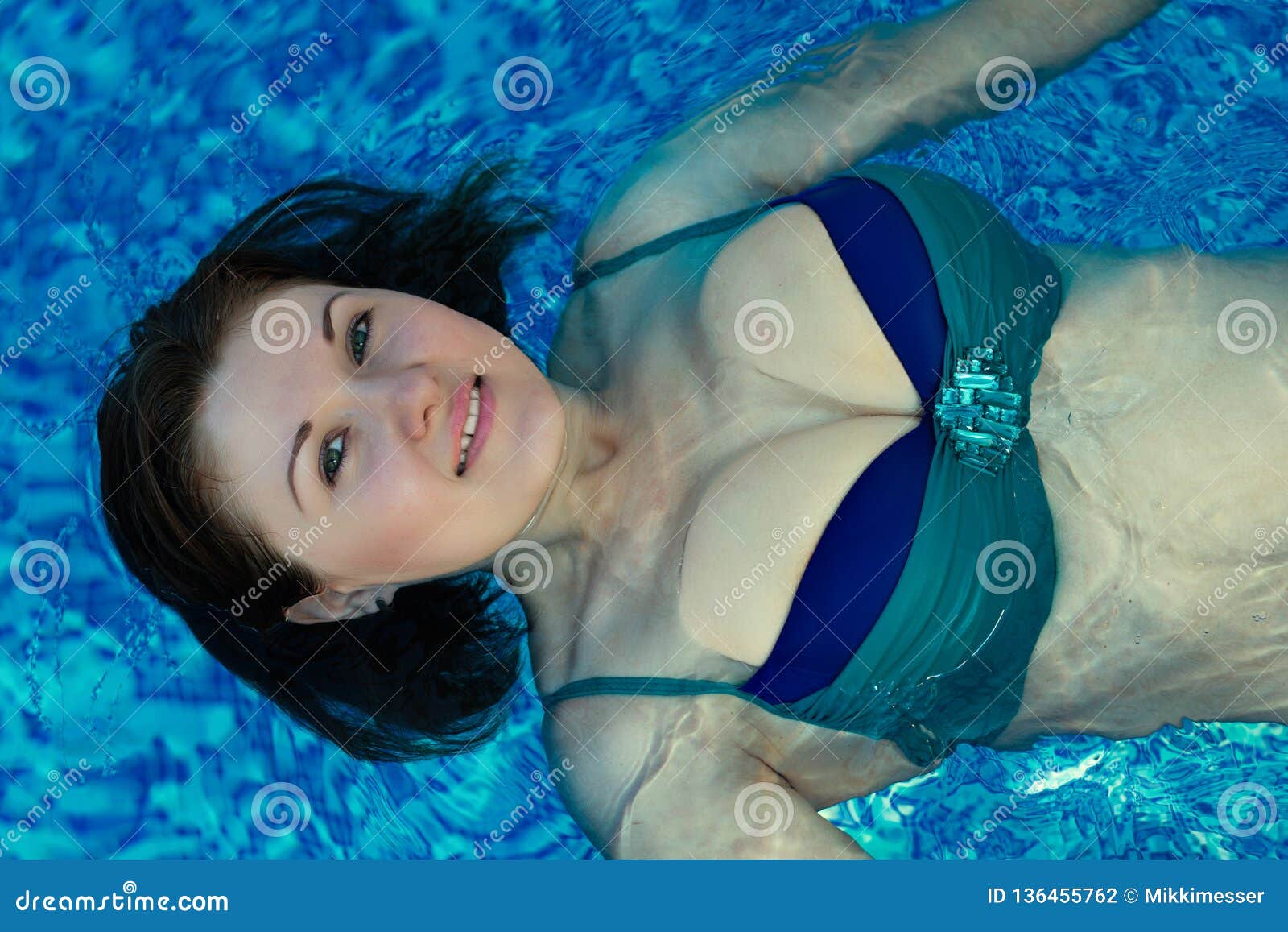 Smiling Woman With Loose Hair Swimming Backstroke In A Bi