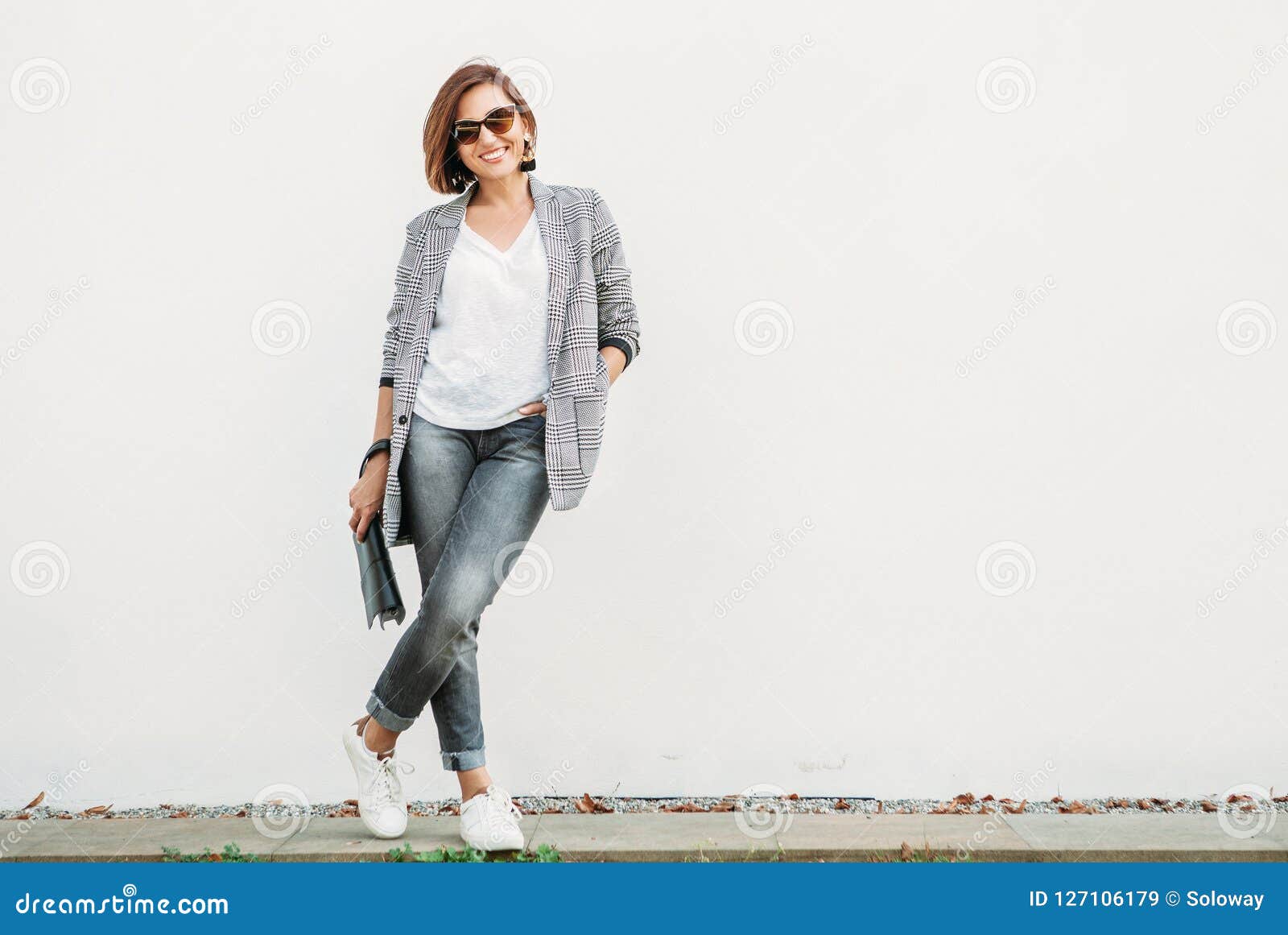 smiling woman posing in casual city outfit in black and gray col