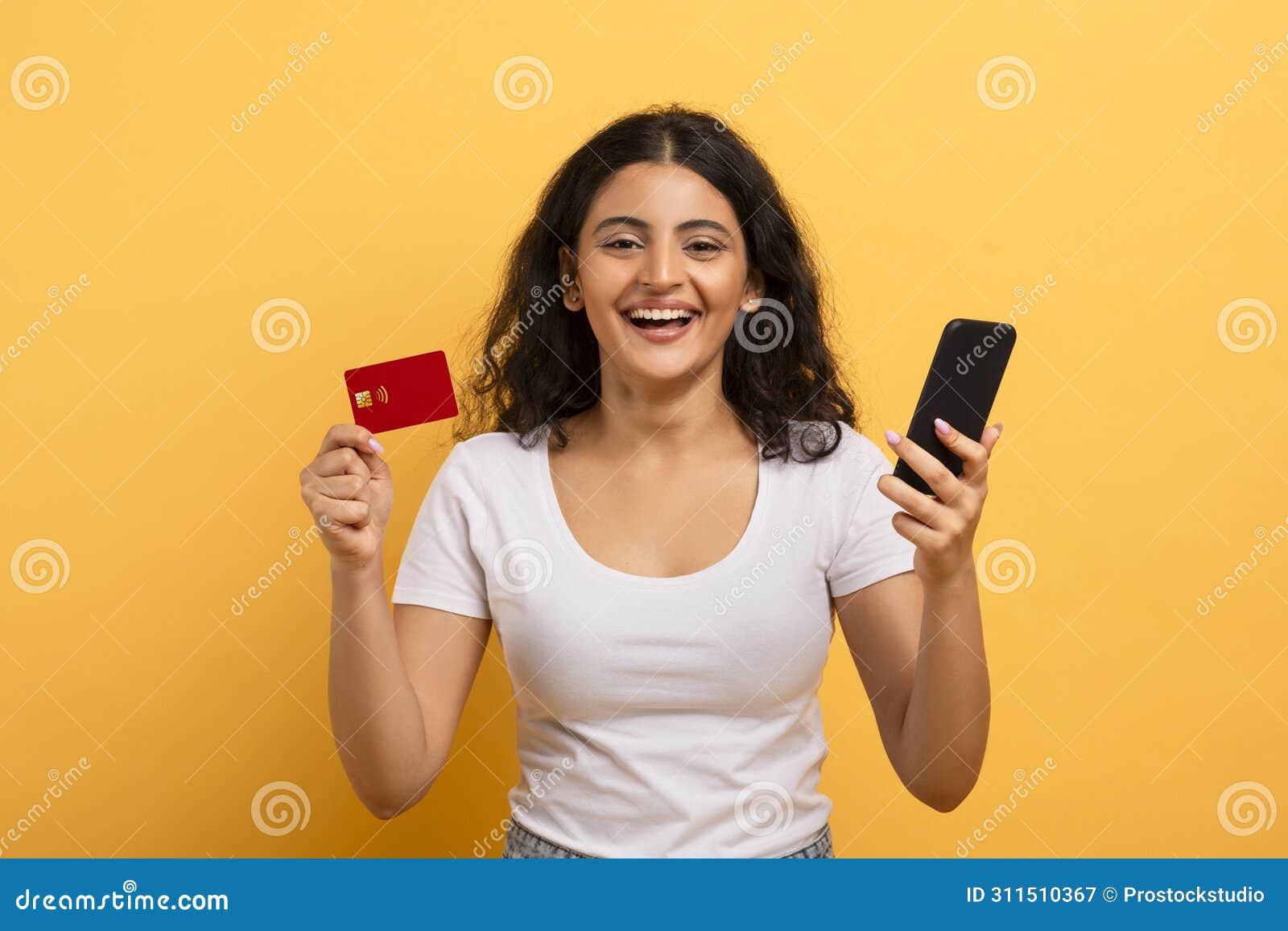 cheerful woman holding phone and credit card