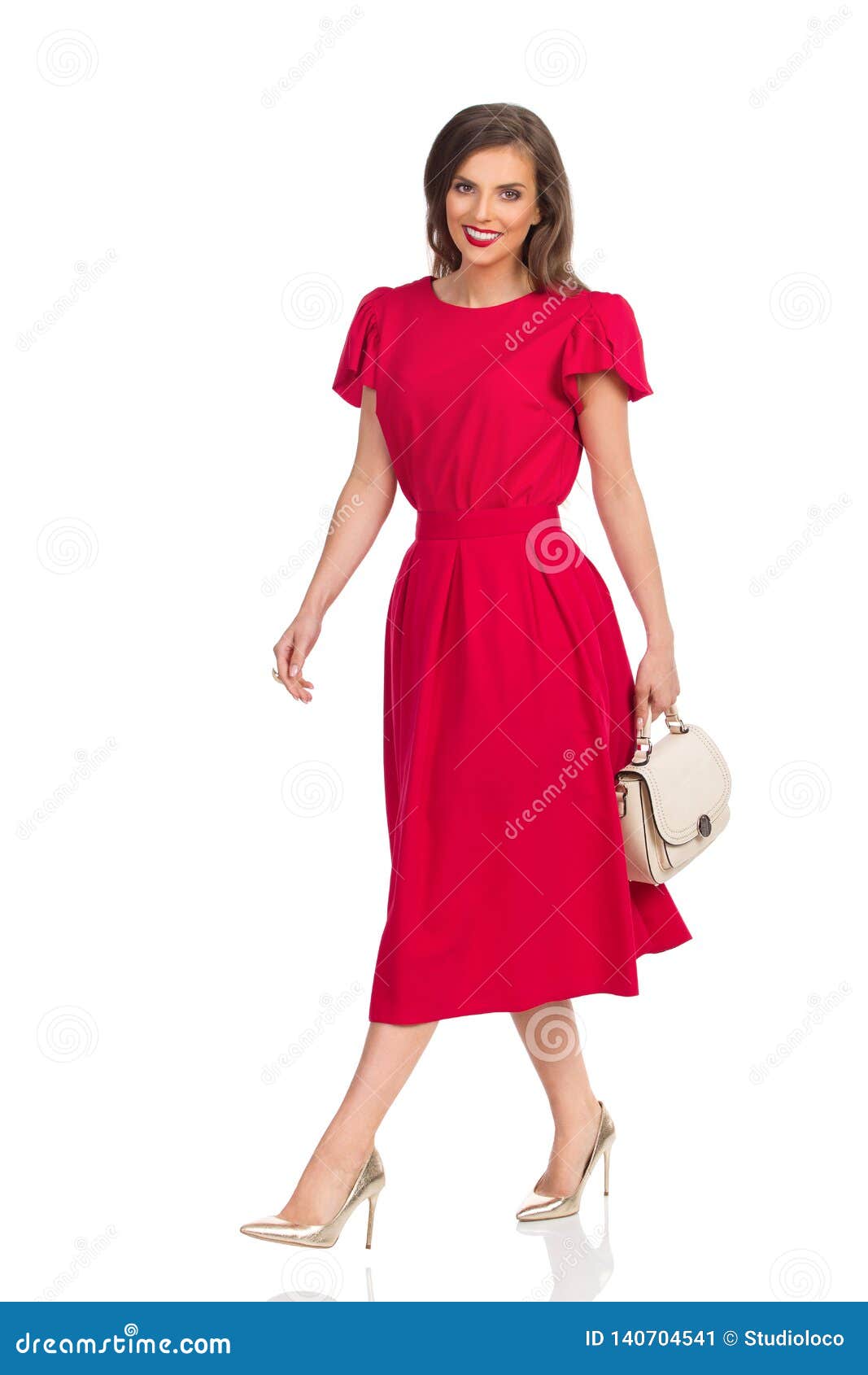 Smiling Woman in Red Dress, Gold High Heels and Beige Purse is Walking ...