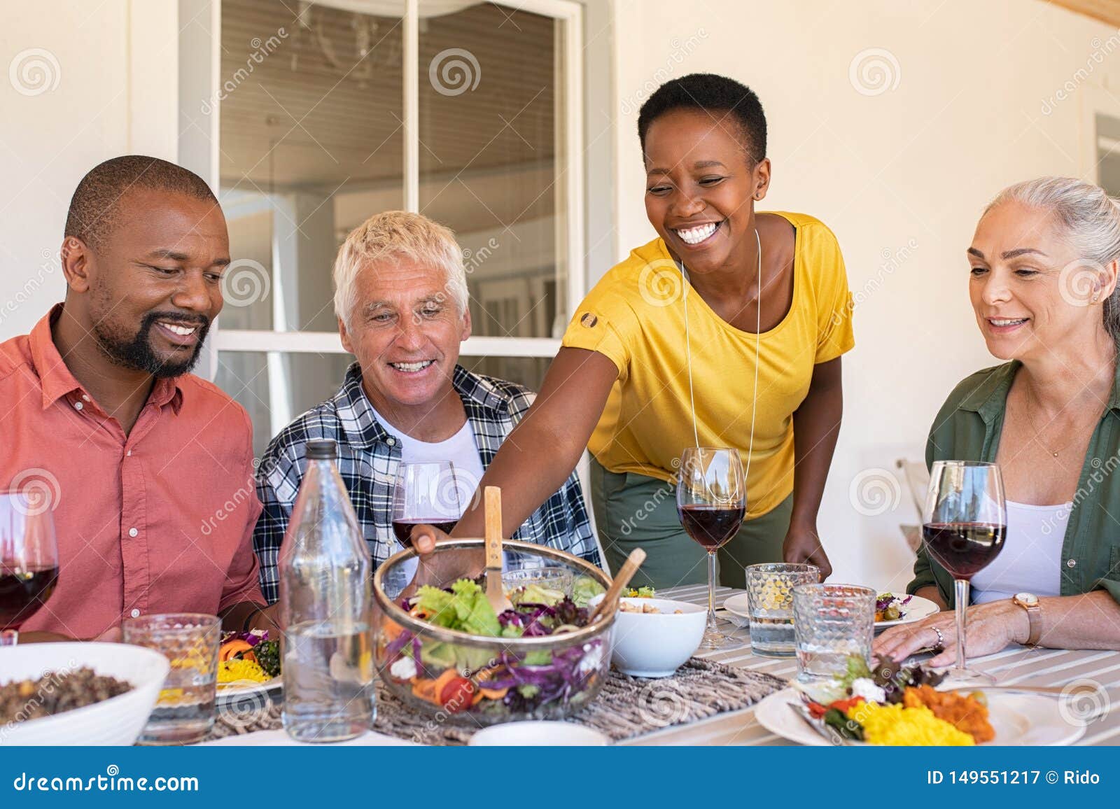 smiling woman serving bowl of salad