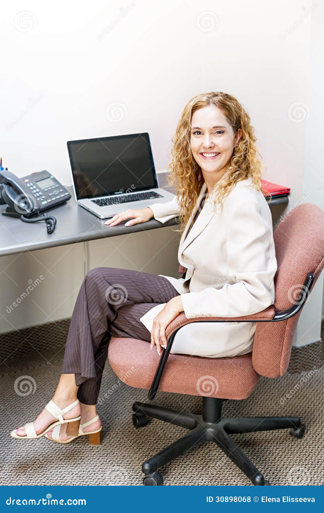 Smiling Woman Sitting At Office Desk Royalty Free Stock Photos - Image