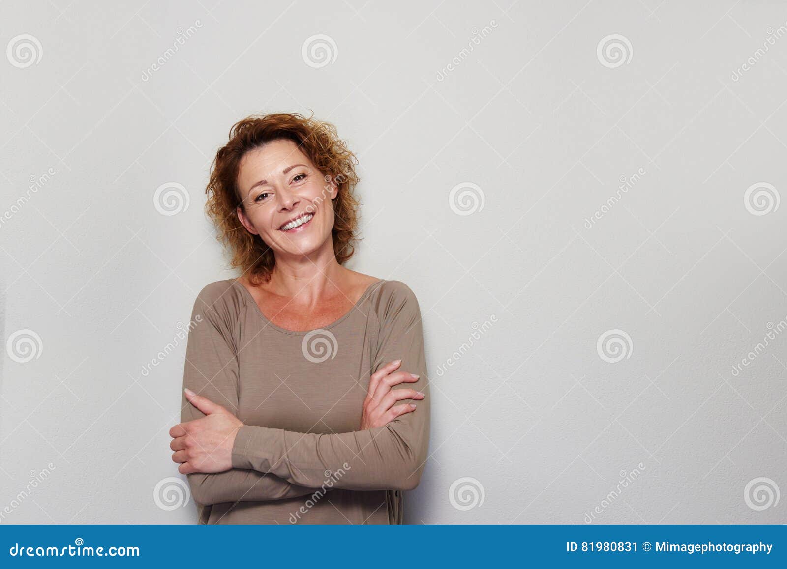smiling woman standing with arms crossed