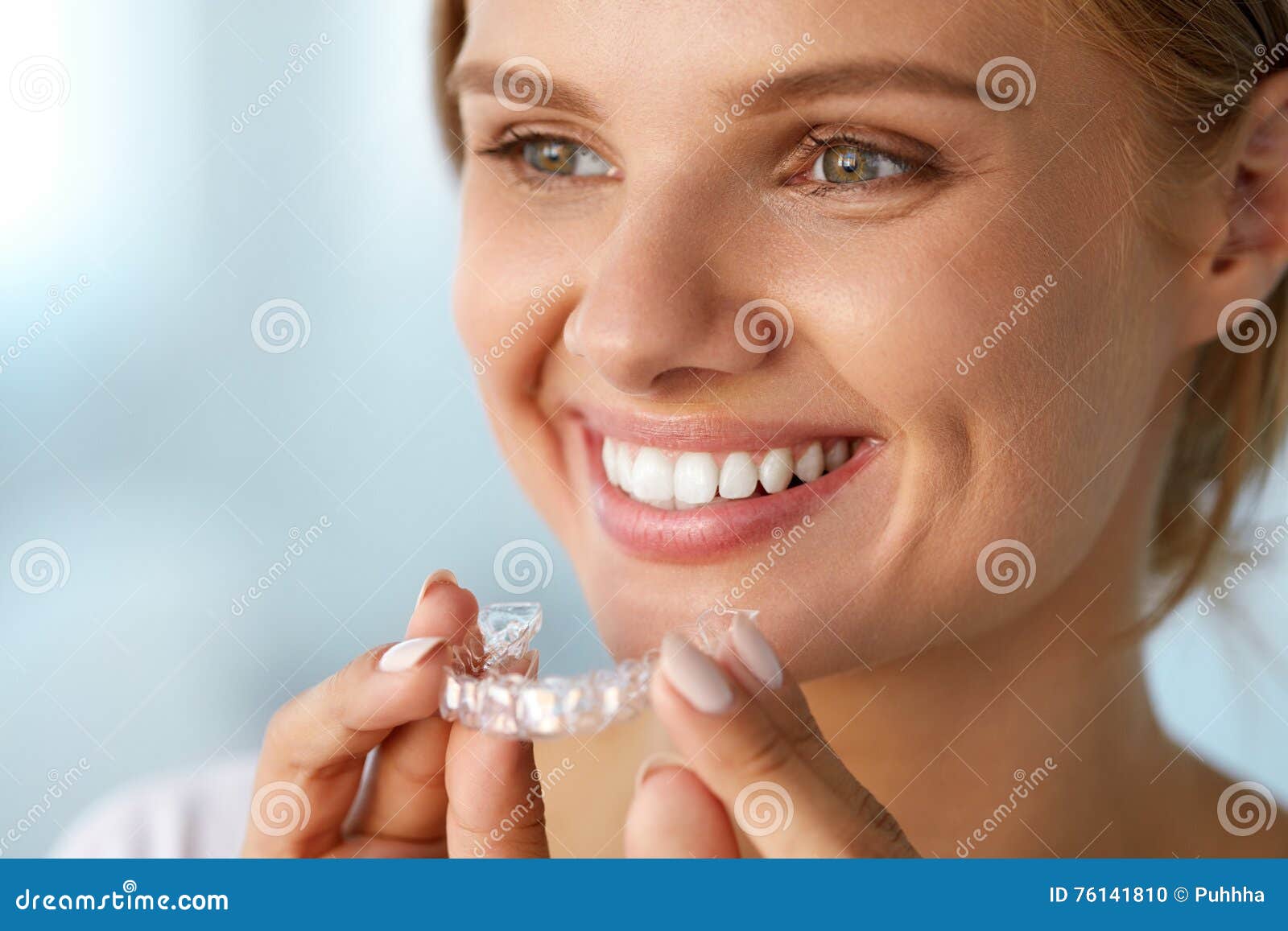 smiling woman with white teeth holding teeth whitening tray
