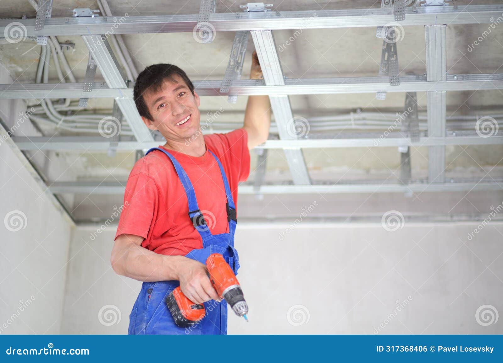 smiling worker is installing a ceiling profile for