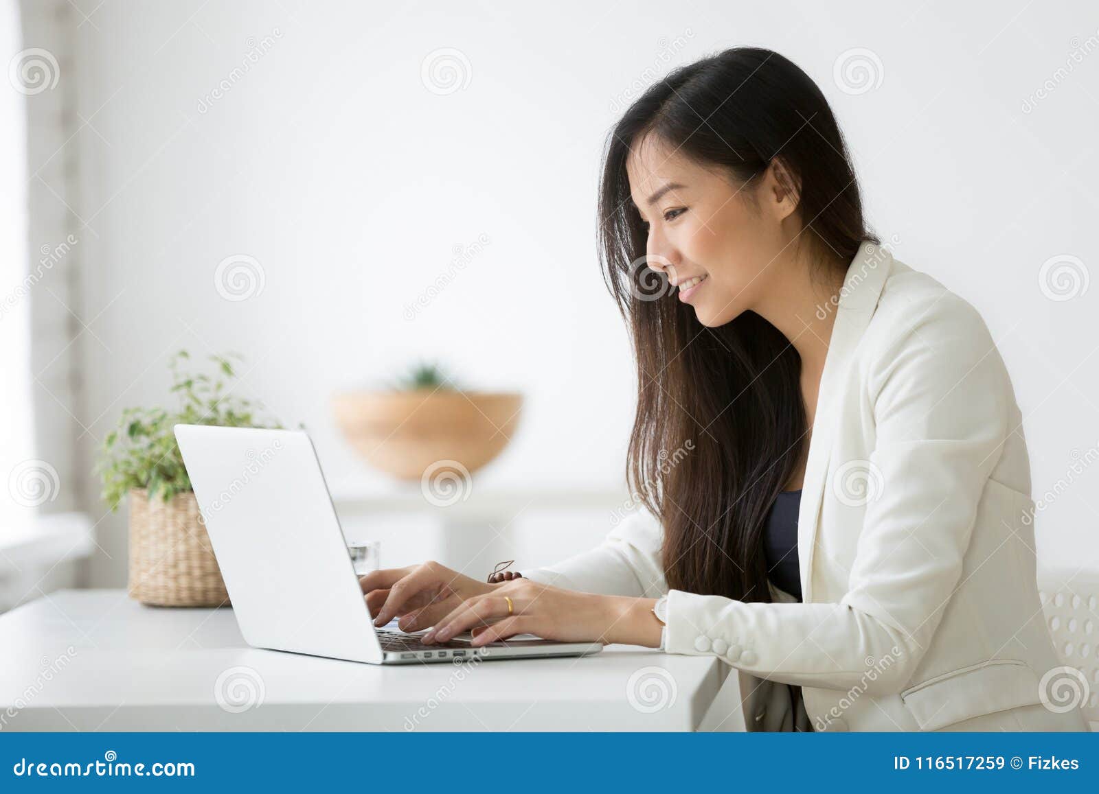 smiling young asian businesswoman using computer working online