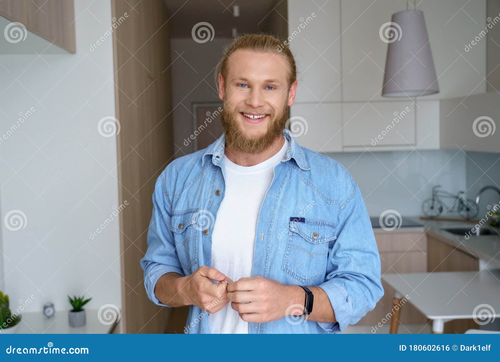 smiling young man first time estate owner hold key to new home look at camera.