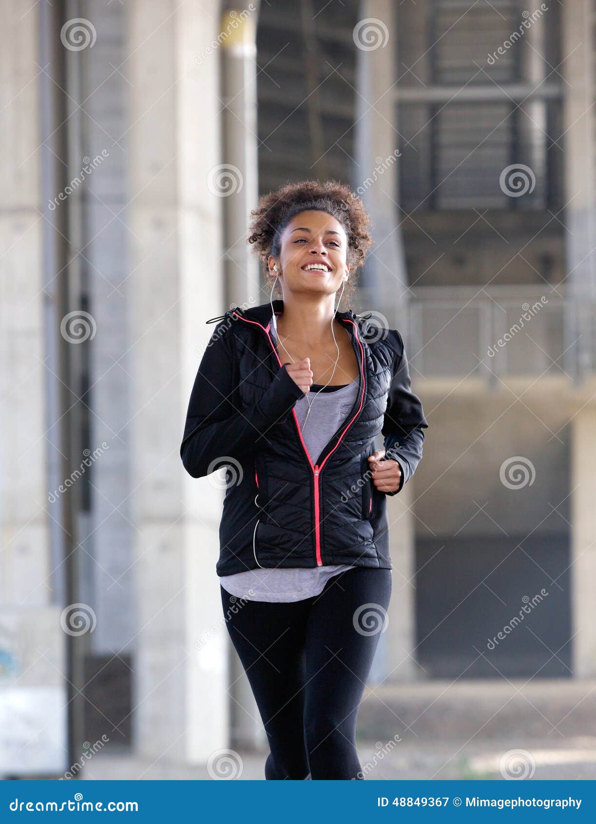 Fit Beautiful Young Woman Running In The Park. She Is Wearing