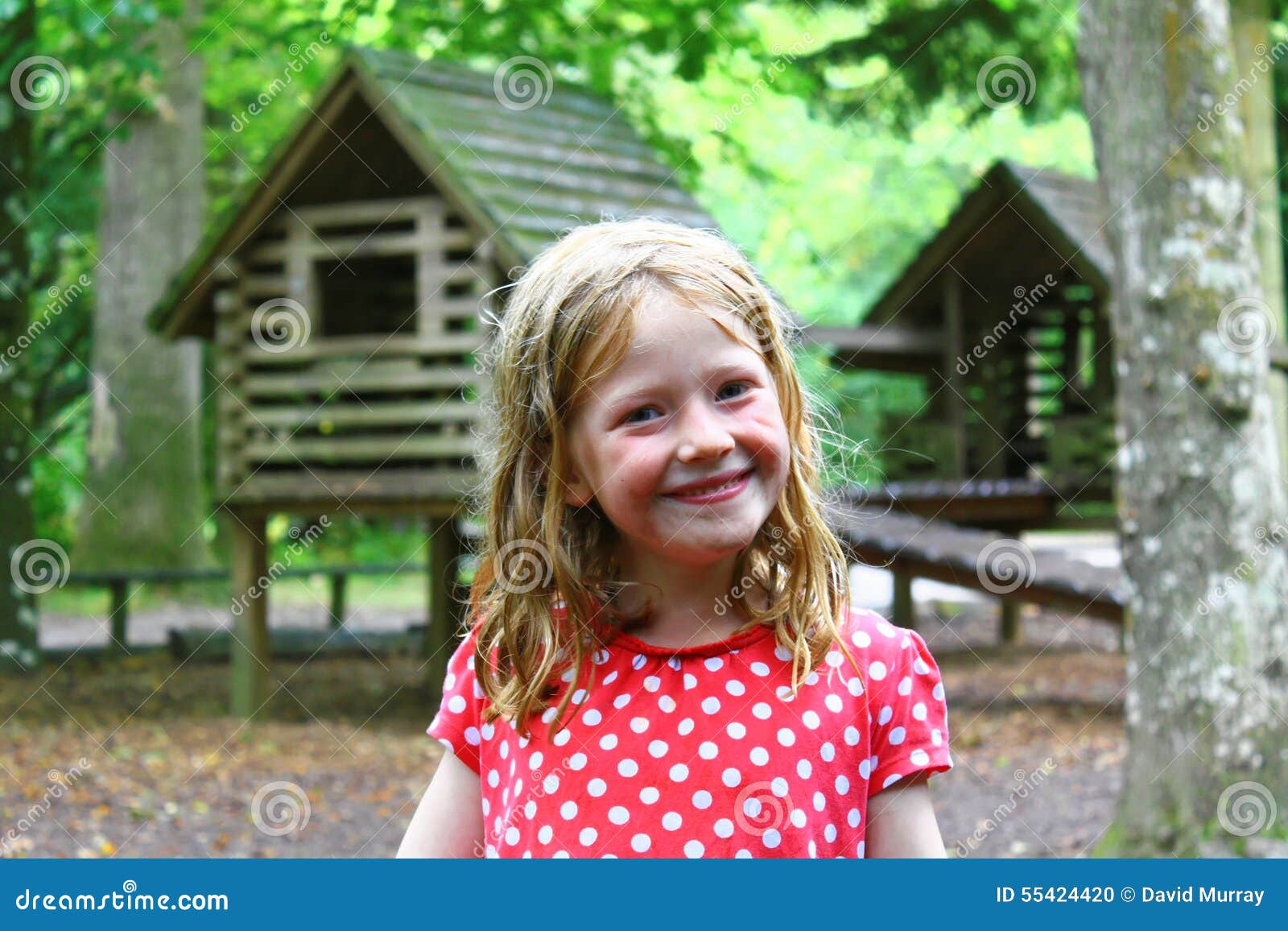 smiling young blonde girl playing out - wet, messy, dirty, bedraggled and happy