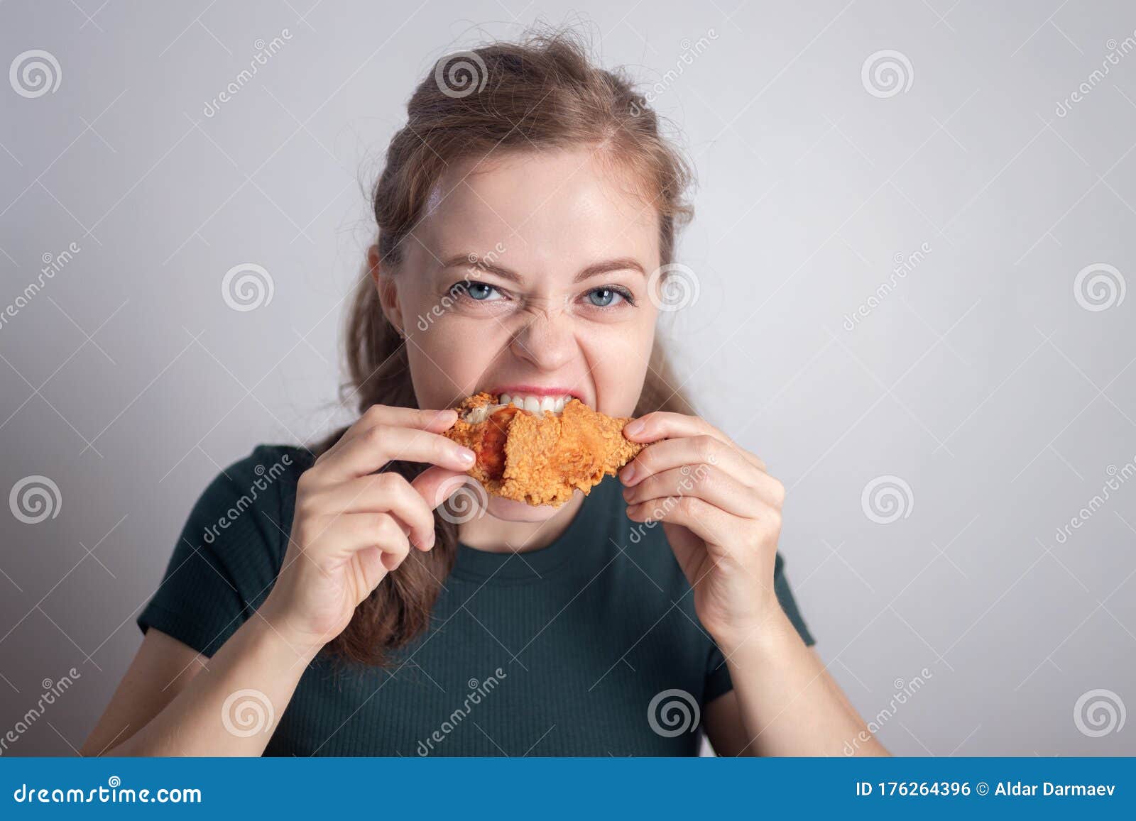 smiling young caucasian woman girl holding eating fried chicken  drumstick