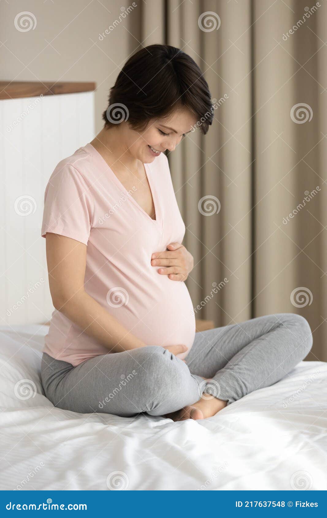 smiling pregnant woman touch caress baby bump