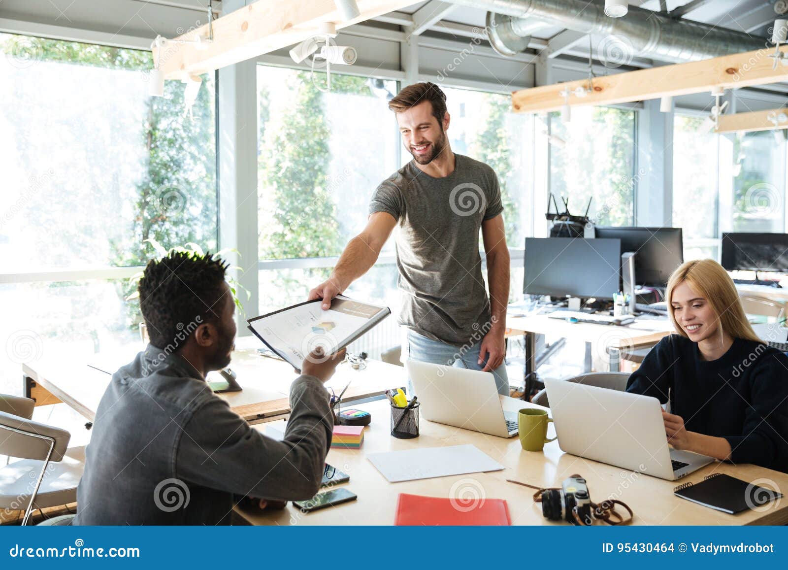 smiling young colleagues sitting in office coworking