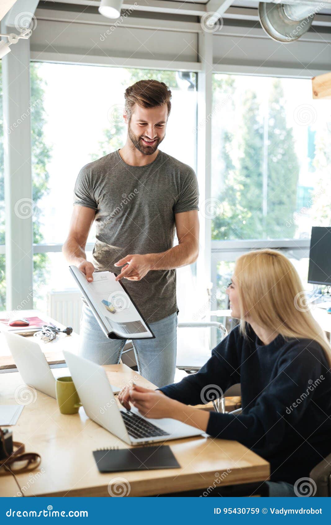 smiling young colleagues sitting in office coworking