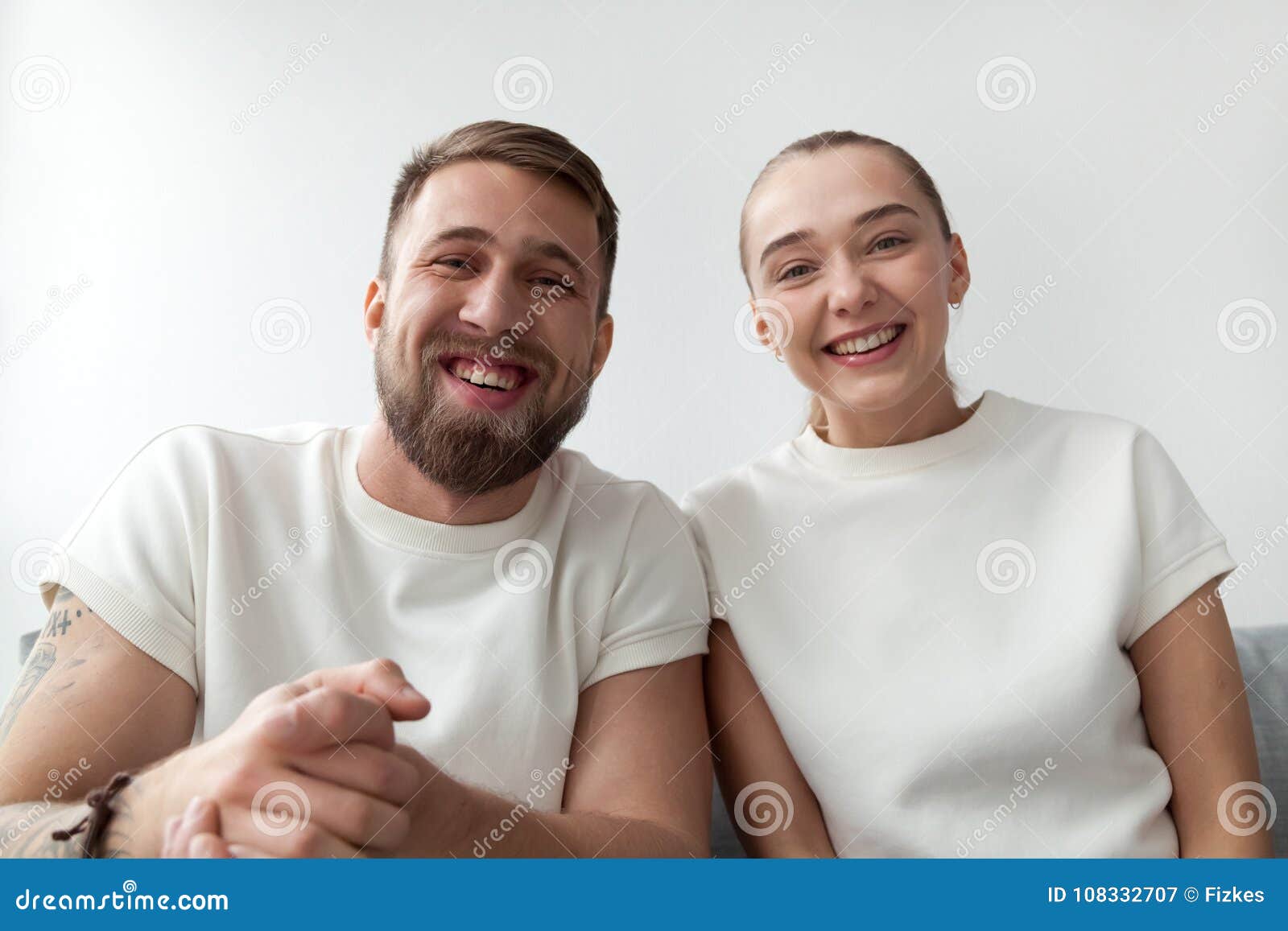 smiling young couple looking at camera, making videocall, webcam